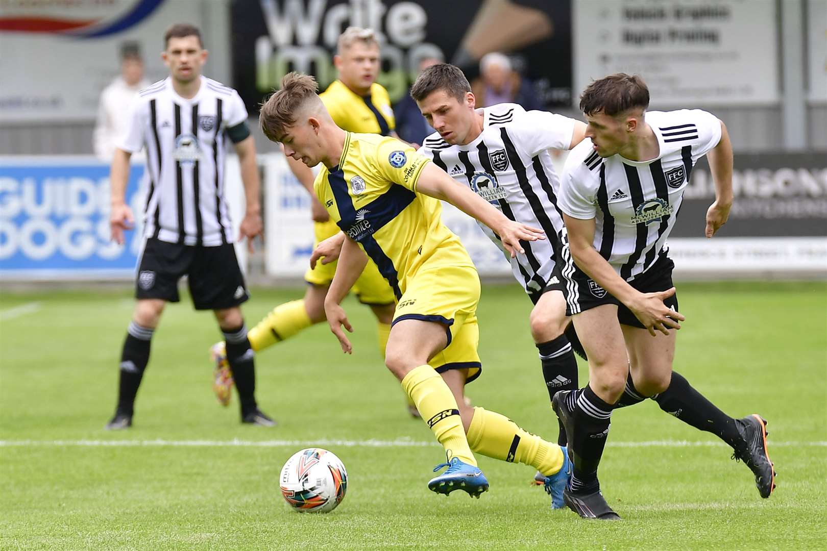 Wick's Harry Hennem drives through Fraserburgh's Ryan Sargent and Paul Young during Saturday's match at Bellslea Park. Picture: Mel Roger