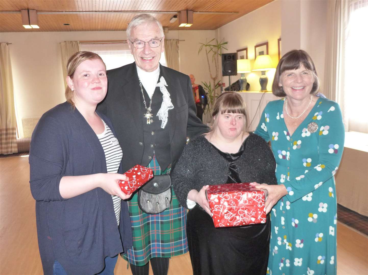 Louise Forbes (second right) receives the winning pass-the-parcel prize from Ruth Sinclair, while Charlene Smith receives the runner-up prize from the Rt Rev Colin Sinclair, at the Enable Caithness autumn afternoon tea dance in Wick's Norseman Hotel. Picture: Willie Mackay