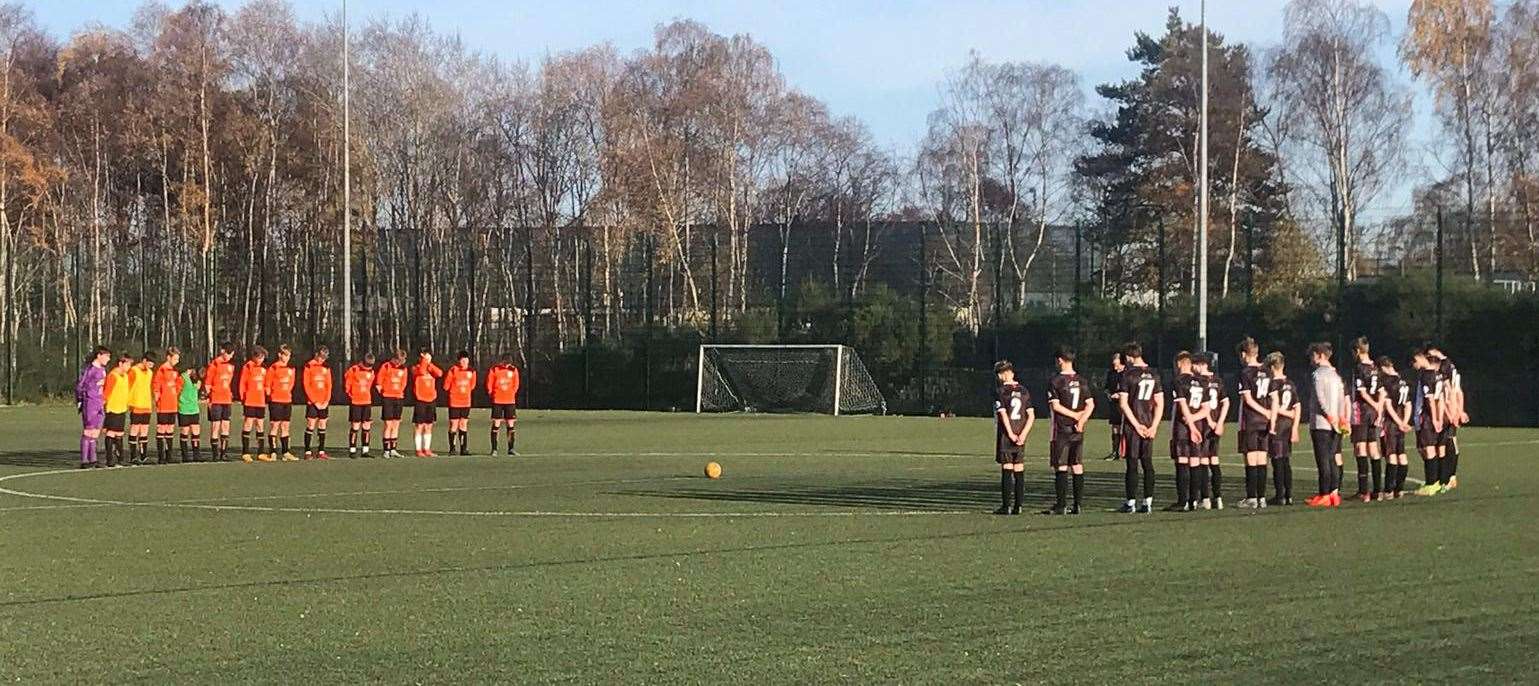 Caithness United and Strathspey under-16s observing a minute's silence before their match on Remembrance Sunday.