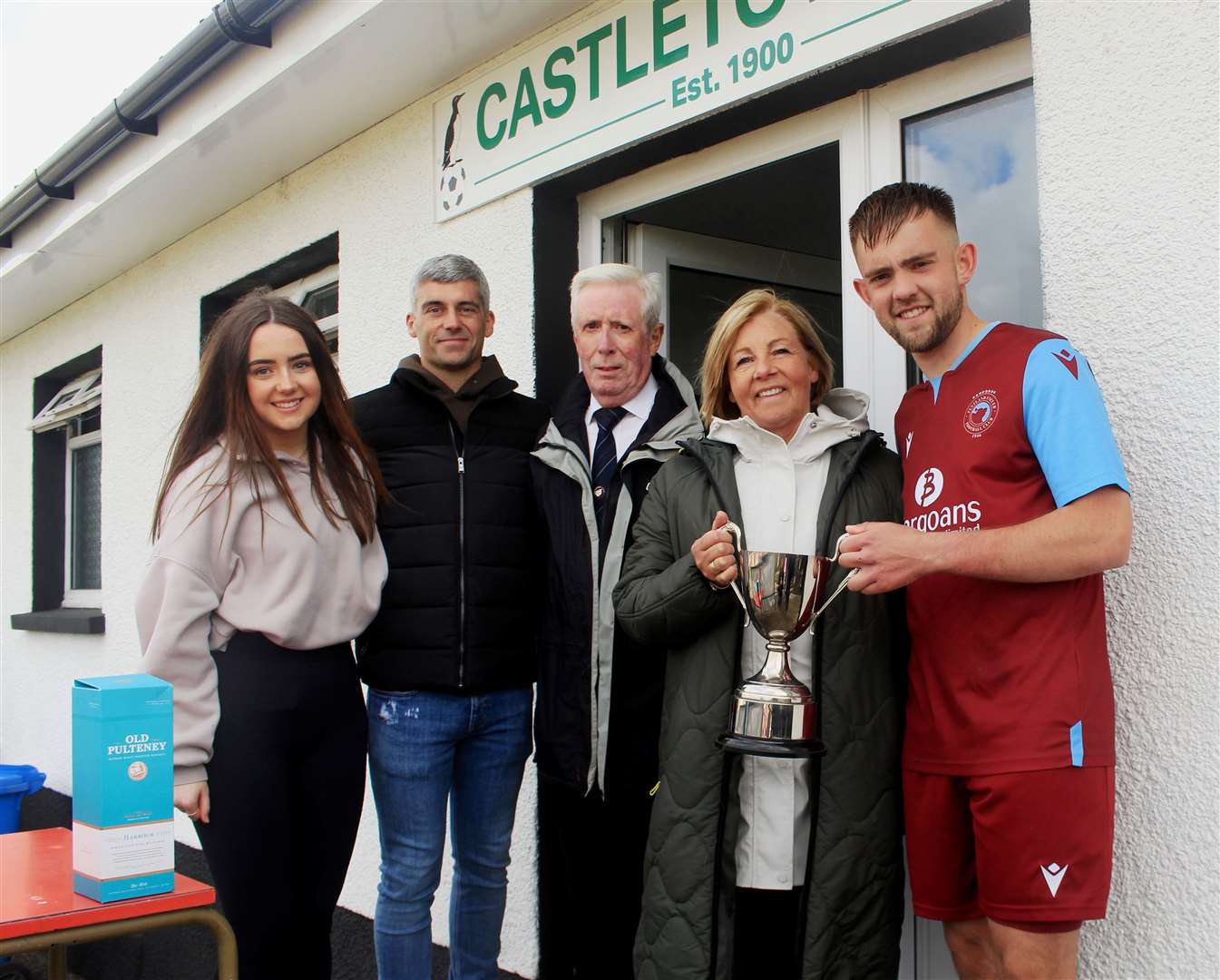 Pentland United’s Luke Manson receiving the Colin Macleod Memorial Cup from Colin’s widow Anita, son Greg and Greg’s daughter Rebecca, with Caithness AFA president Murray Coghill (centre) looking on. Picture: Alan Hendry