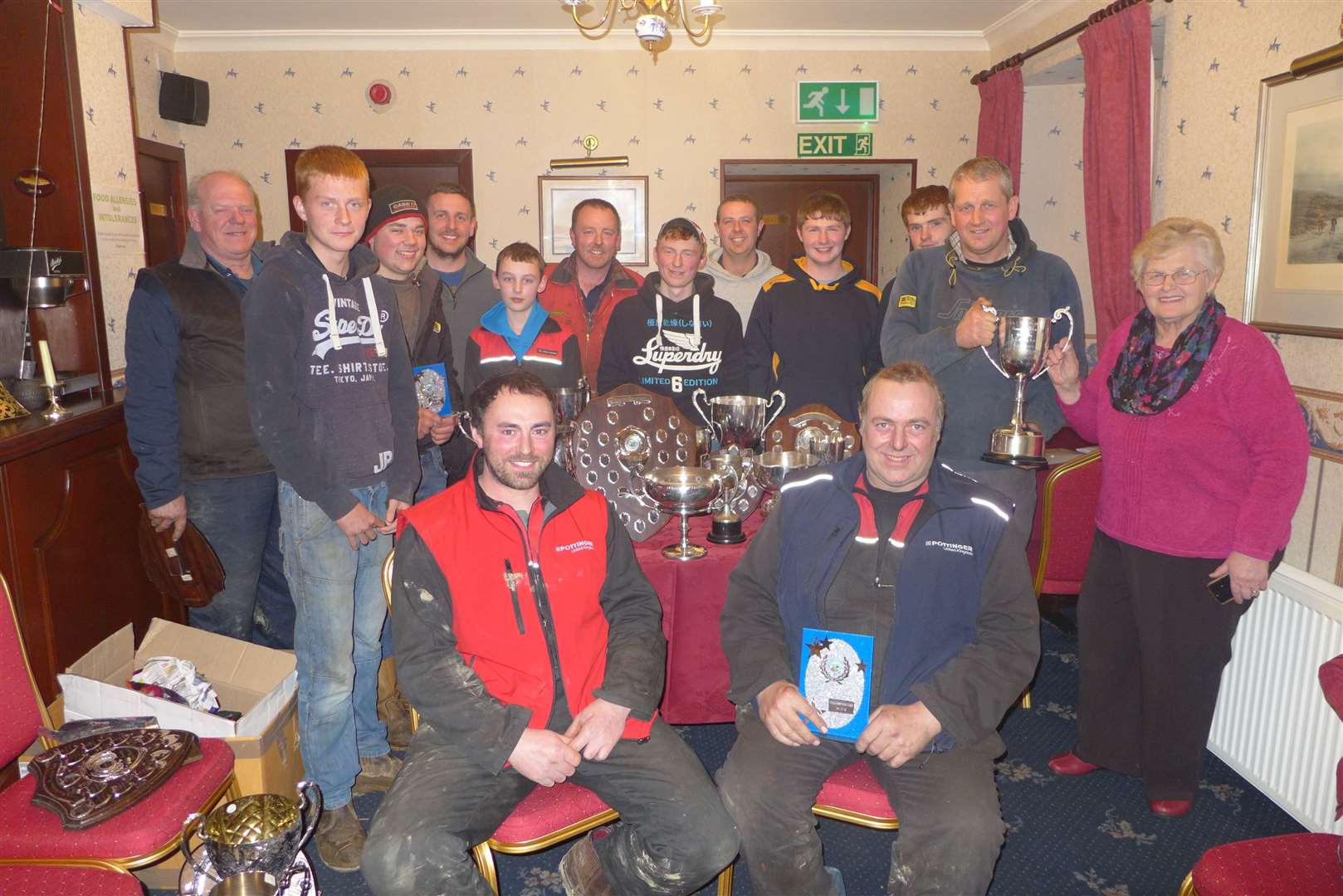 Joanna Mackay, West Greenland, who presented all the trophies, hands over the overall champion's cup to her son, Michael, in the Brown Trout Hotel, Watten, as some of the class winners look on.
