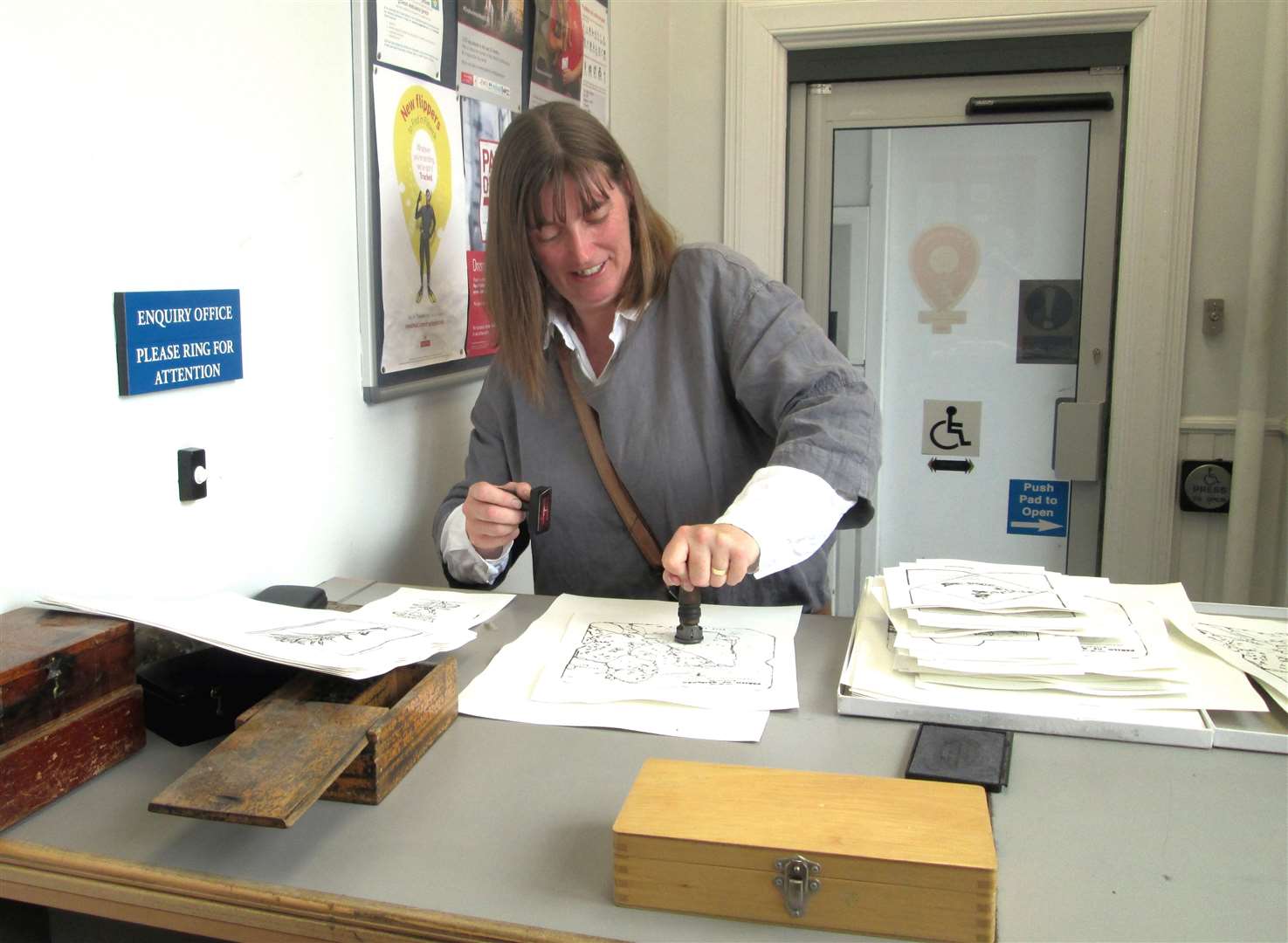 Joanne franks the mail with original lead letter stampers in Thurso Postal Depot.