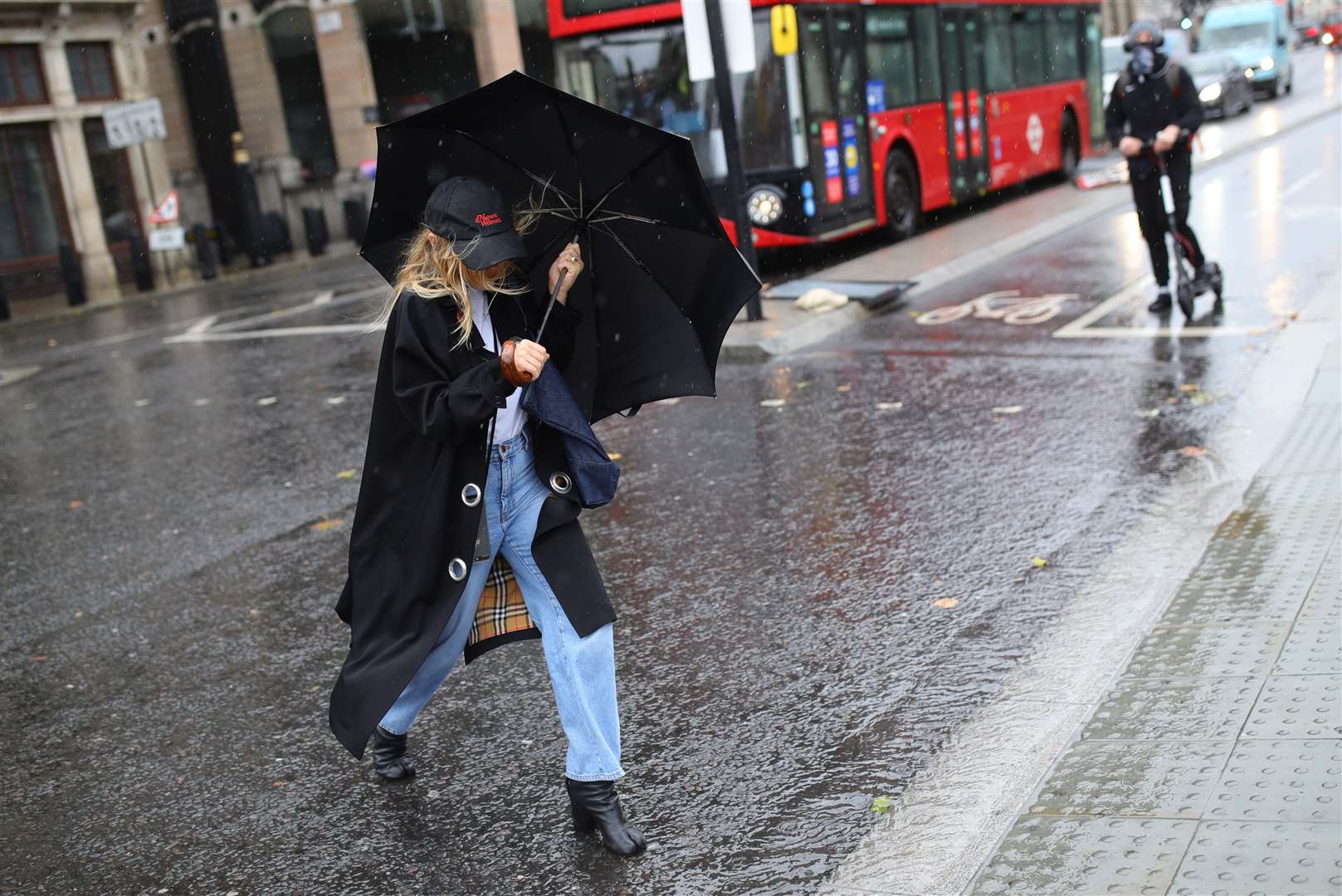 A woman walks through the rain in Westminster on Friday morning (Aaron Chown/PA)