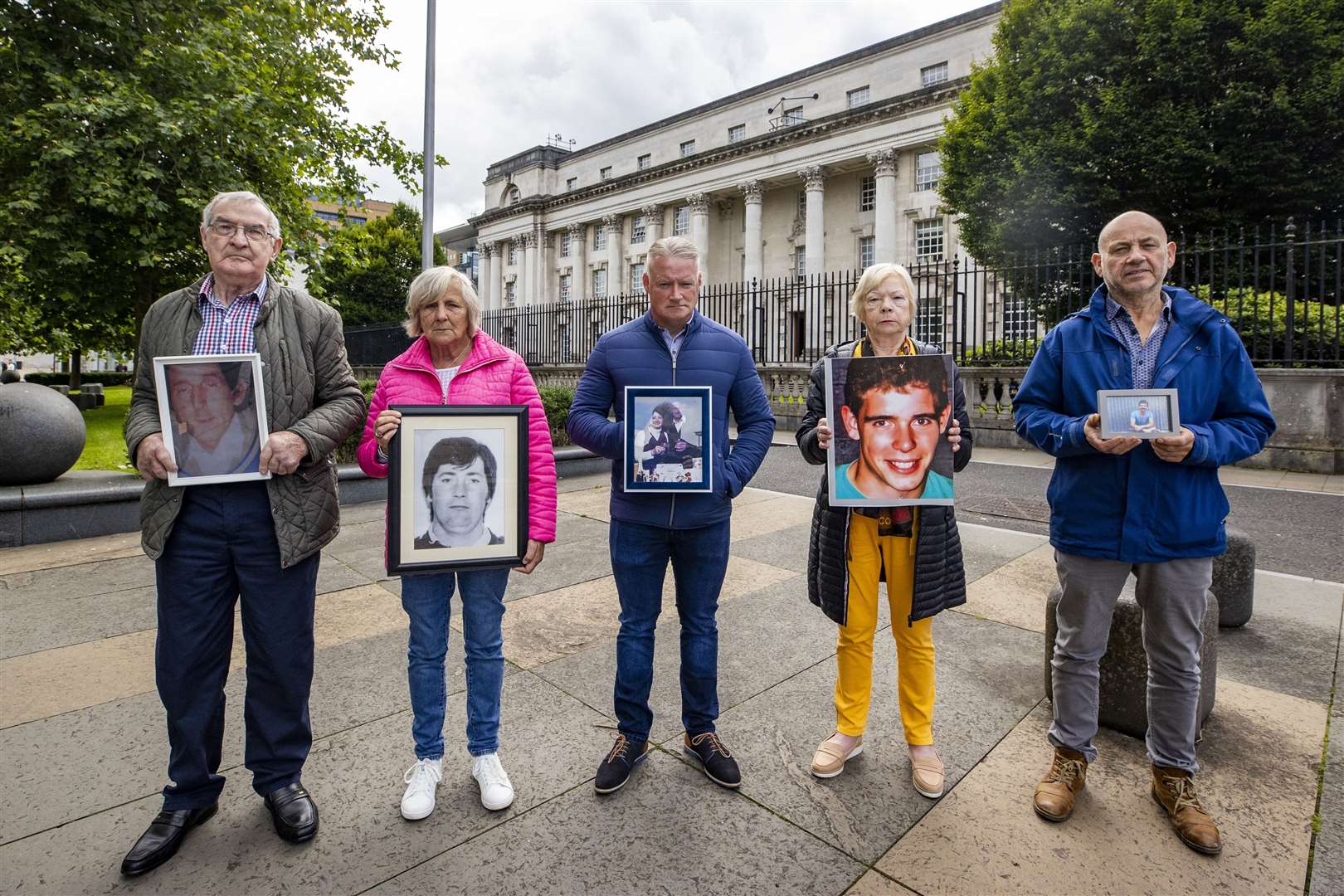 (from left) Michael Armstrong holding an image of his brother Thomas Armstrong, Pauline McNally holding an image of her husband Phelim McNally, Conor Casey holding an image of his parents Kathleen and Tommy Casey, Briege O’Donnell holding an image of her son Dwayne O’Donnell, and Peter Anderson holding an image of his brother Sean Anderson, outside Belfast High Court (Liam McBurney/PA)