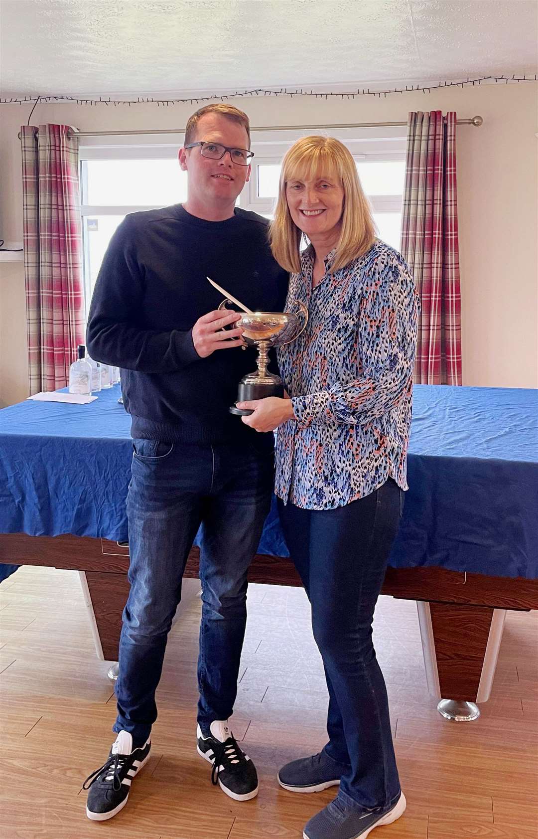 Brent Munro receiving the scratch trophy from Carol Paterson.
