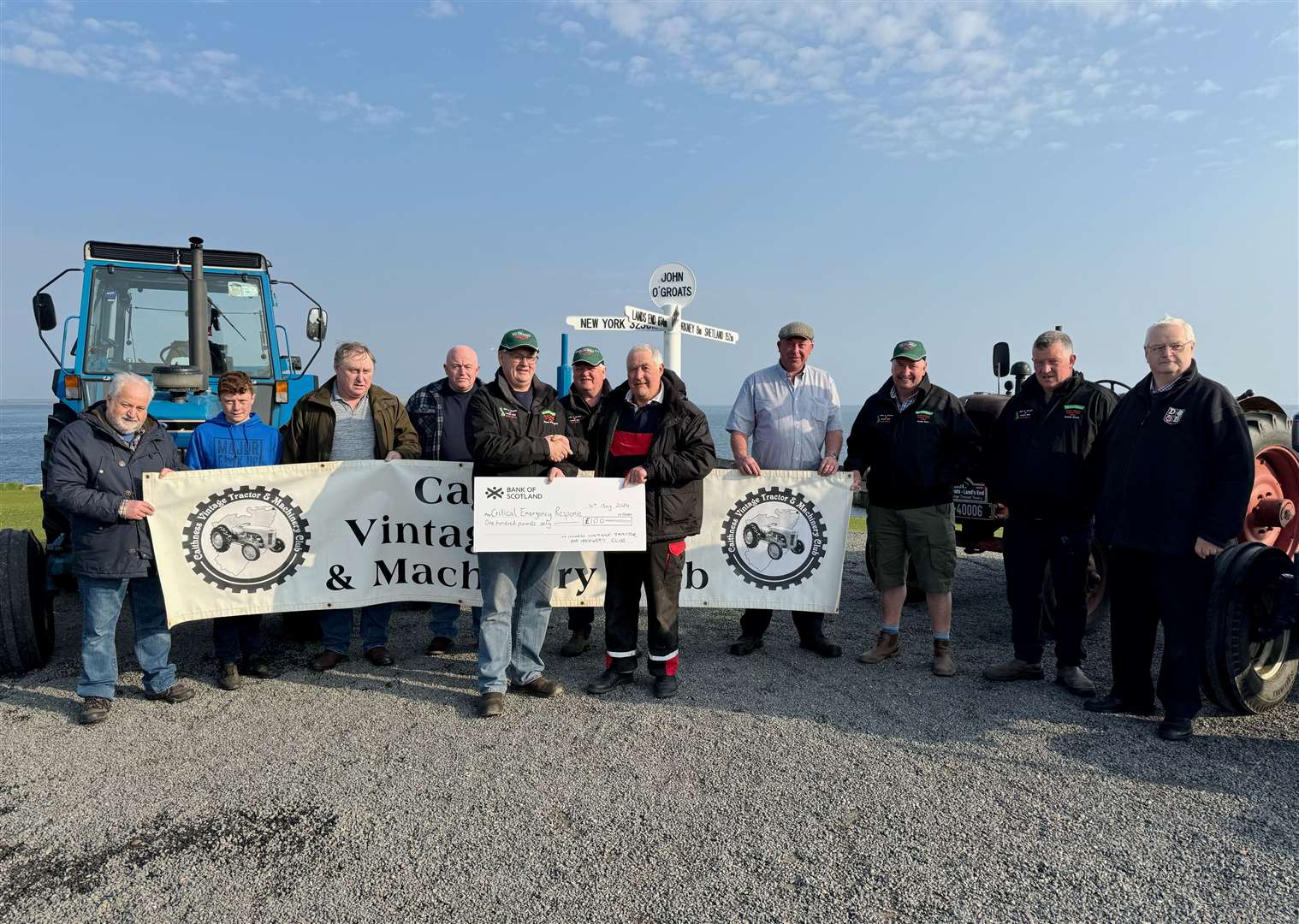 Brian Polson (front, right), vice-chairman of Caithness Vintage Tractor and Machinery Club, handing over a cheque for £100 to Kieran O’Donoghue for the Irish Rovers’ Great Vintage Tractor Tour 2024. Picture: Donal O’Lochlainn