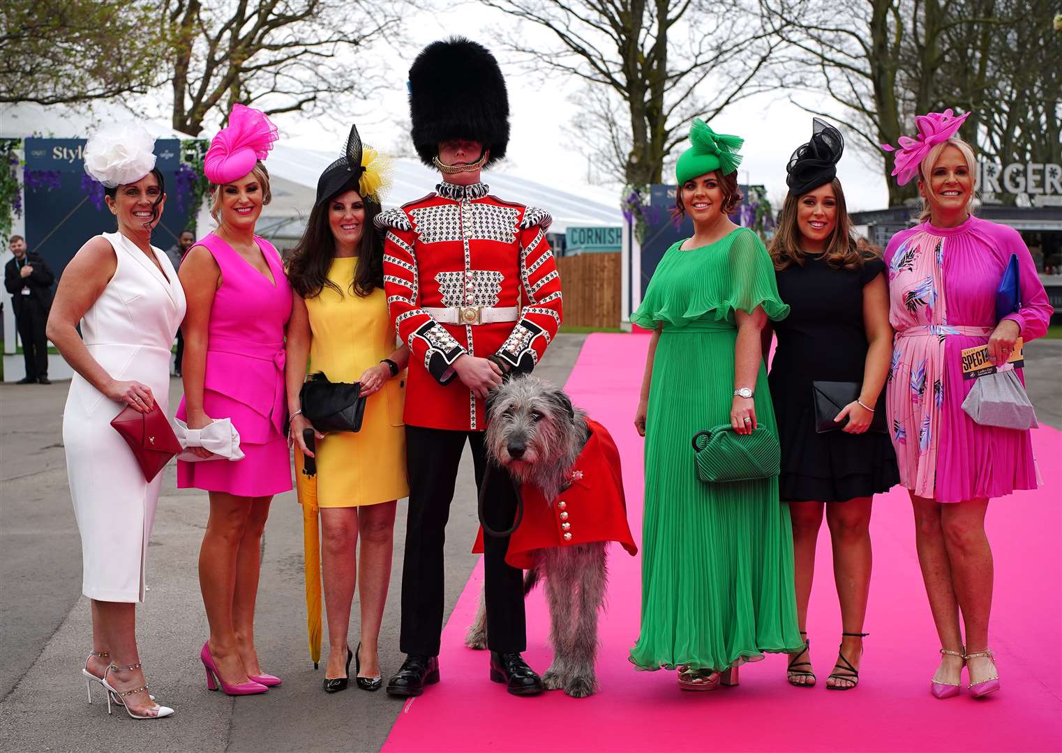 Racegoers pose for a photograph with a guard and a wolfhound in the Red Rum Garden (Peter Byrne/PA)
