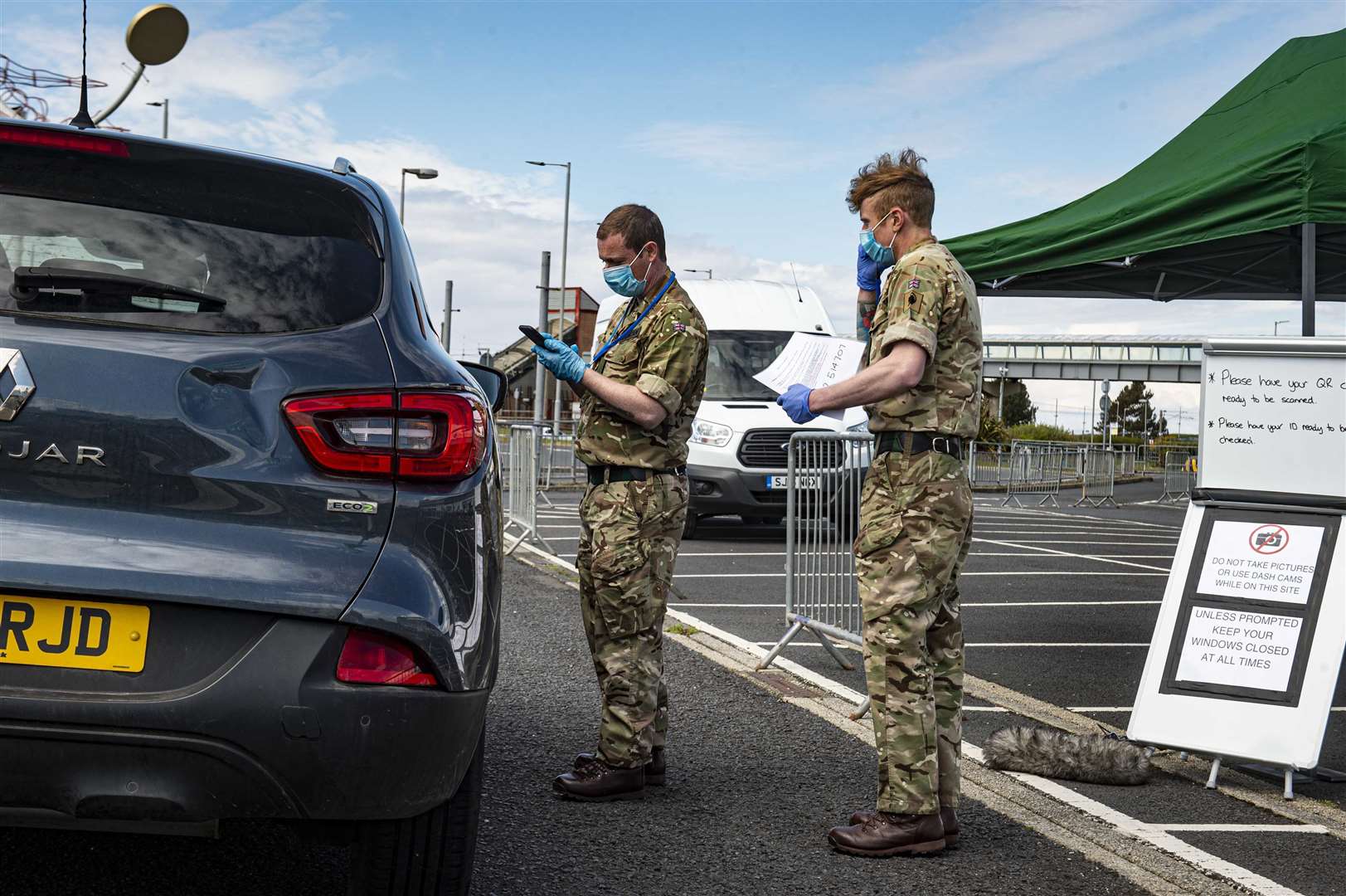 Military personnel manning a mobile testing unit in another part of Scotland, providing a drive-through service for eligible people.