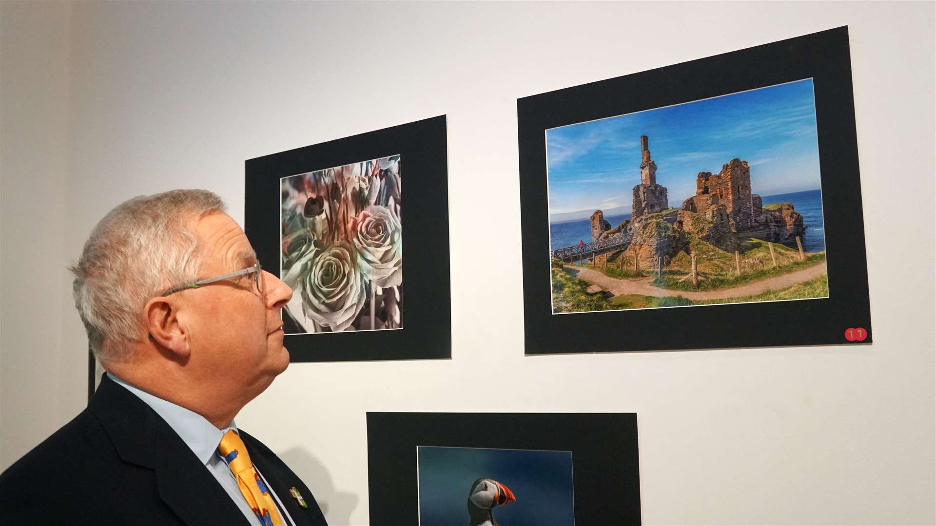 Richard Griffith, vice chair of Thurso Camera Club, looks at his photograph of Sinclair Girnigoe Castle which was taken last summer. Picture: DGS