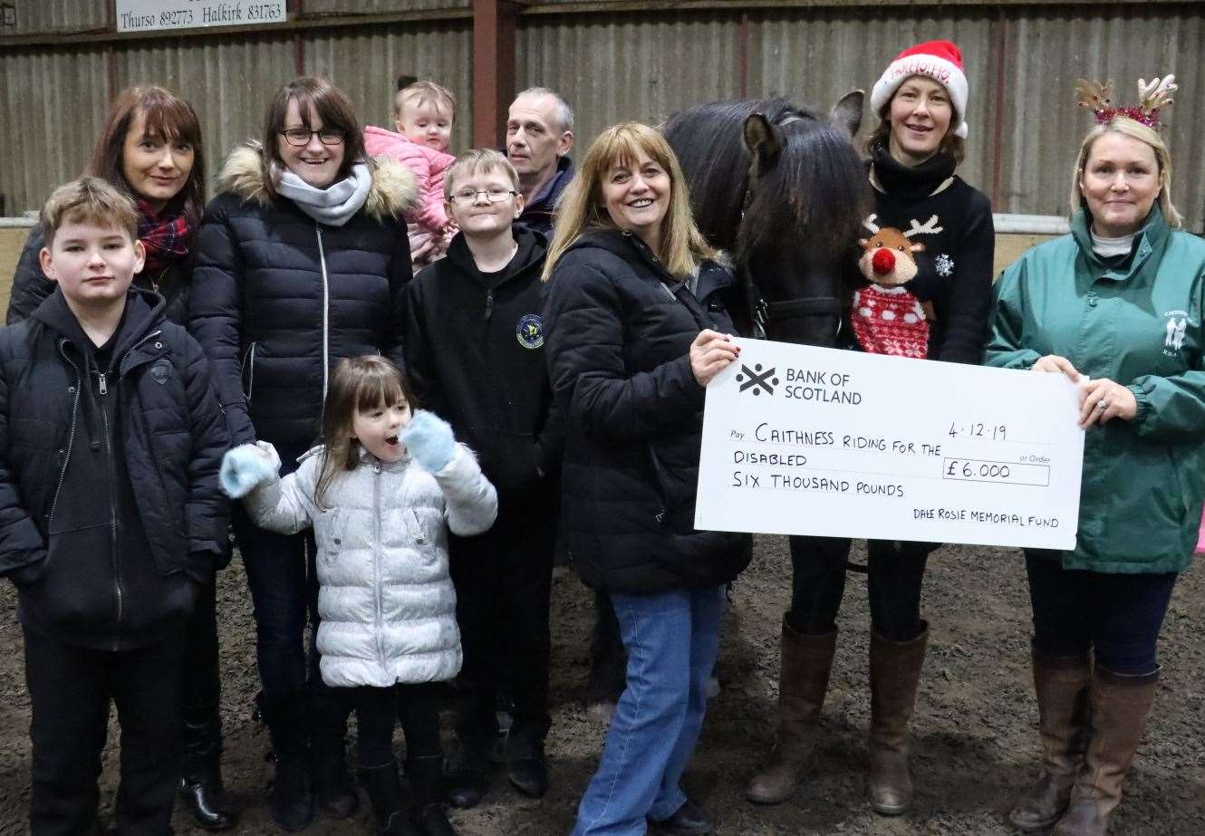 Claire Fraser (back left) along with members of her family handing over a cheque for £6000 to the Caithness RDA group chairperson Judith Miller (right) last December.