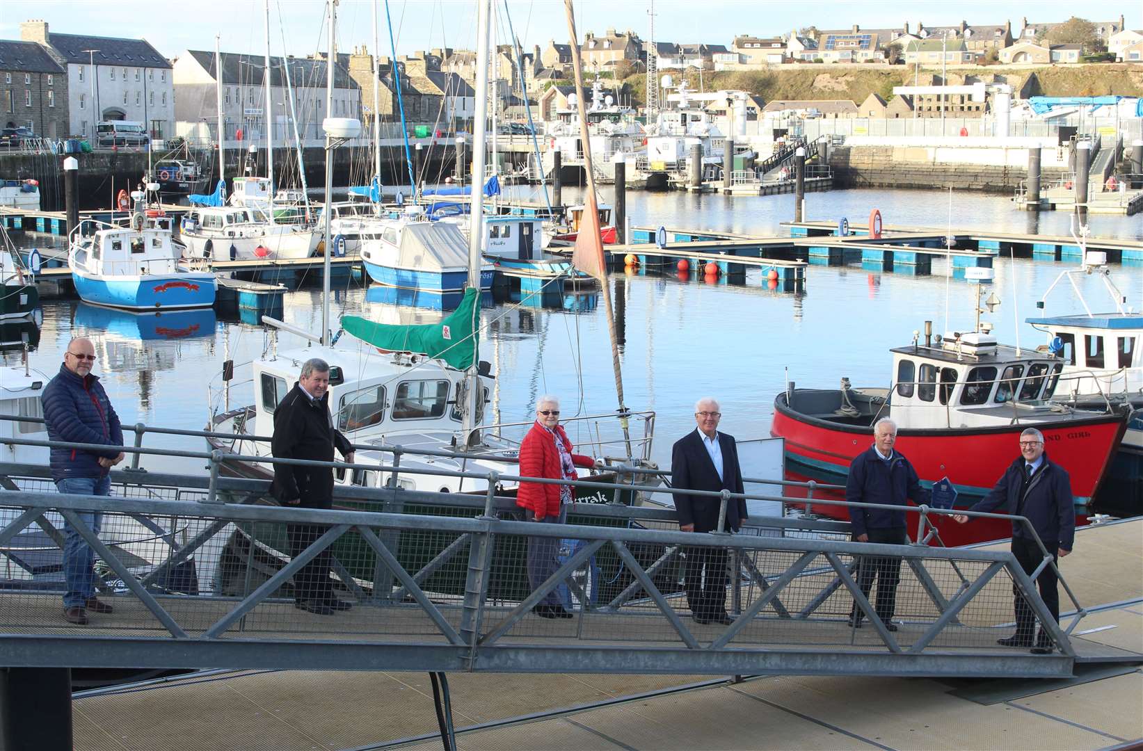 John Mackay hands the engraved glass plaque to Willie Watt in the marina, which was the first major project undertaken by Wick Harbour Authority. Looking on at Wednesday's presentation are other members of the harbour board. Picture: Alan Hendry