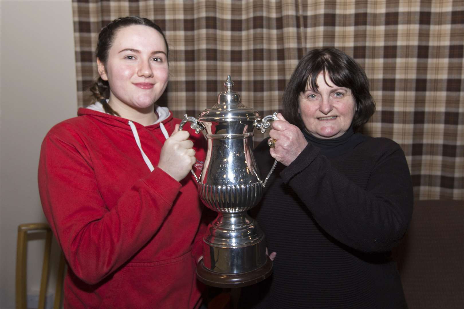 Caitlin Green (left), of Westfield, has continued her domination of the Daisy 2000 junior shooting events by once again winning the indoor trophy, which she first won last year. She is also the holder of the Daisy outdoor trophy which she won in 2018 and again in 2019. The Thurso High School pupil was the first female to have won a Daisy 2000 trophy and has now had four consecutive wins. The indoor shoot at Stirkoke Rifle Club on Thursday night has a record entry of 11 juniors. The trophy was handed over by Caithness Small Bore Rifle Association's secretary, Marty Simpson. Picture: Robert MacDonald / Northern Studios