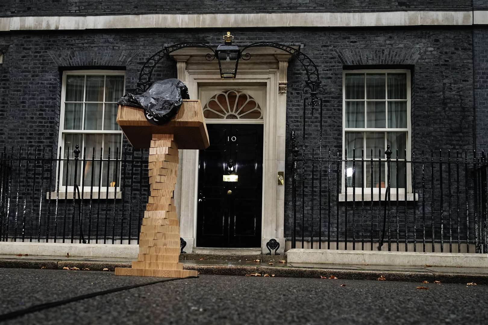 The lectern for Liz Truss’s speech is covered in a bin bag outside 10 Downing Street after a rain downpour before the arrival of the new prime minister from Balmoral (Aaron Chown/PA)