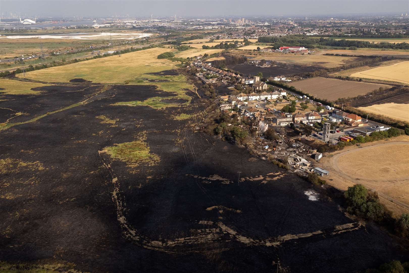Aerial view of burned fields and properties after the blaze in Wennington, east London in July (Aaron Chown/PA)