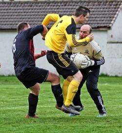 Halkirk goalkeeper Ian Miller saves as Staxigoe’s John Budge (in yellow) closes in. Photo: www.jamesgunn.co.uk