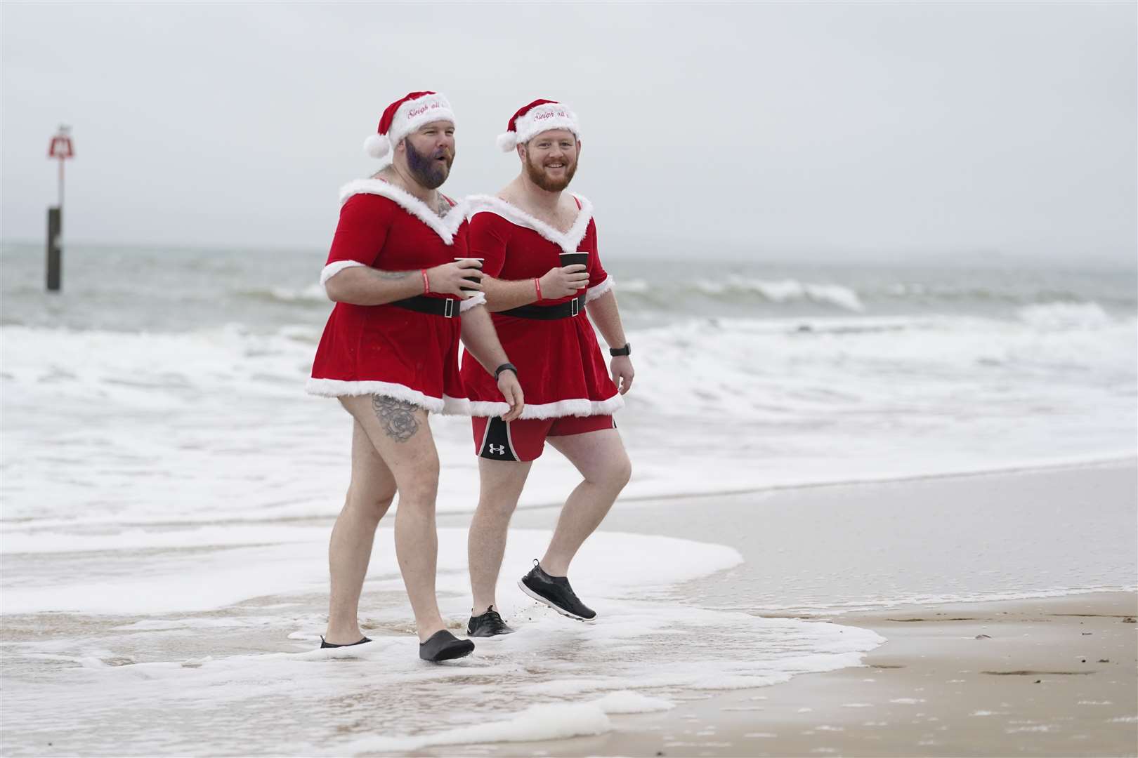 Two swimmers check the water before the start of the Macmillan Boscombe White Christmas Dip (Andrew Matthews/PA)