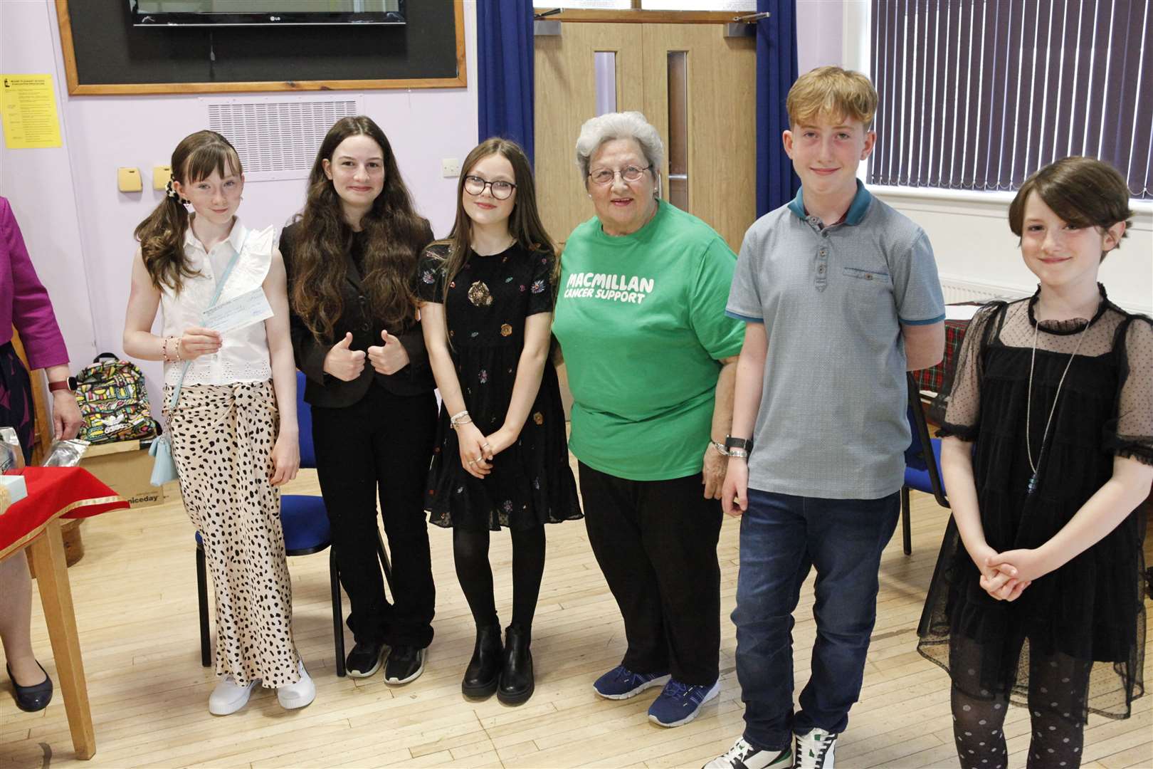 Primary 7 house captains present a cheque for £100 to Sheila Sinclair for the local branch of Macmillan.