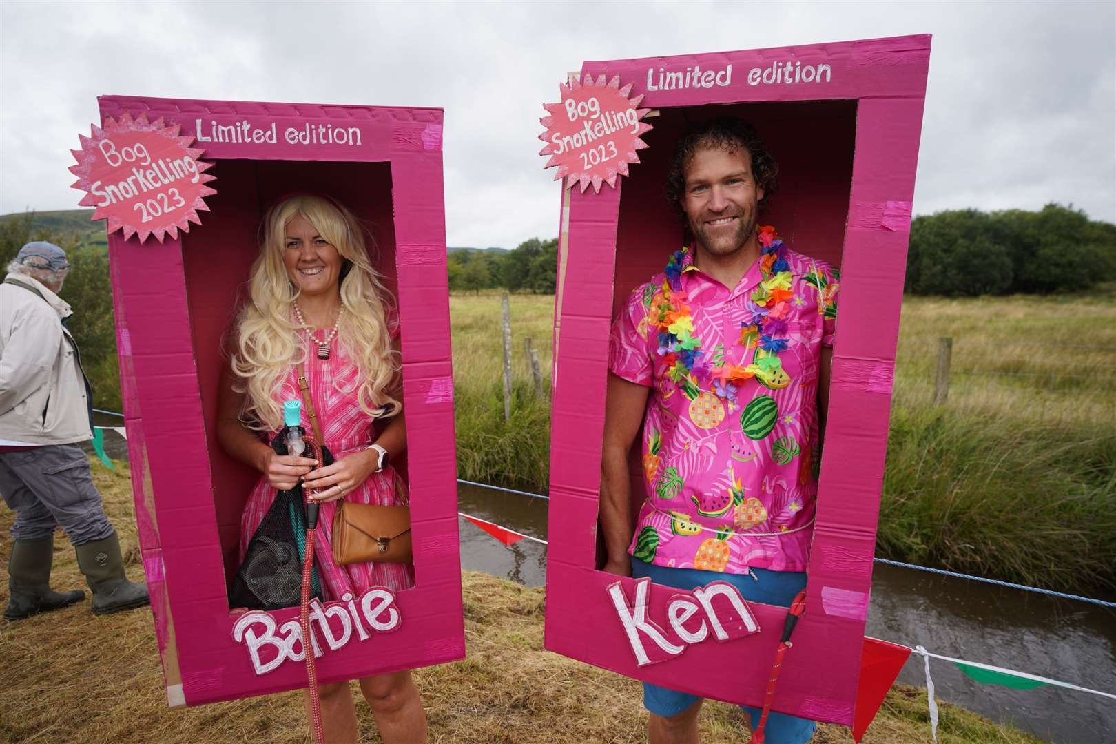 Spectators dressed as Barbie and Ken kept their presentation boxes dry (Ben Birchall/PA)
