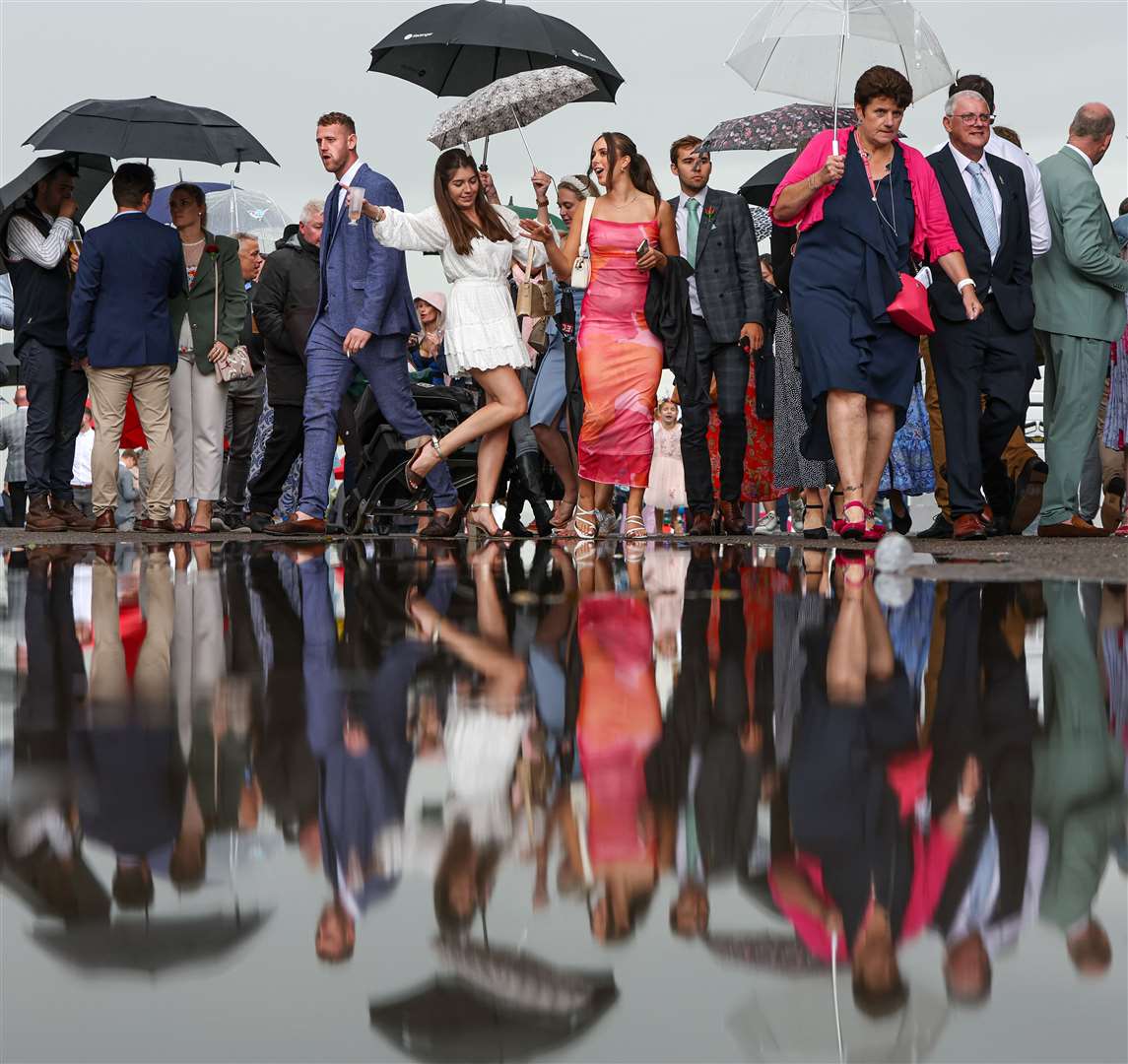 Racegoers walk past a giant puddle on day five of the Qatar Goodwood Festival (KieranCleeves/PA)