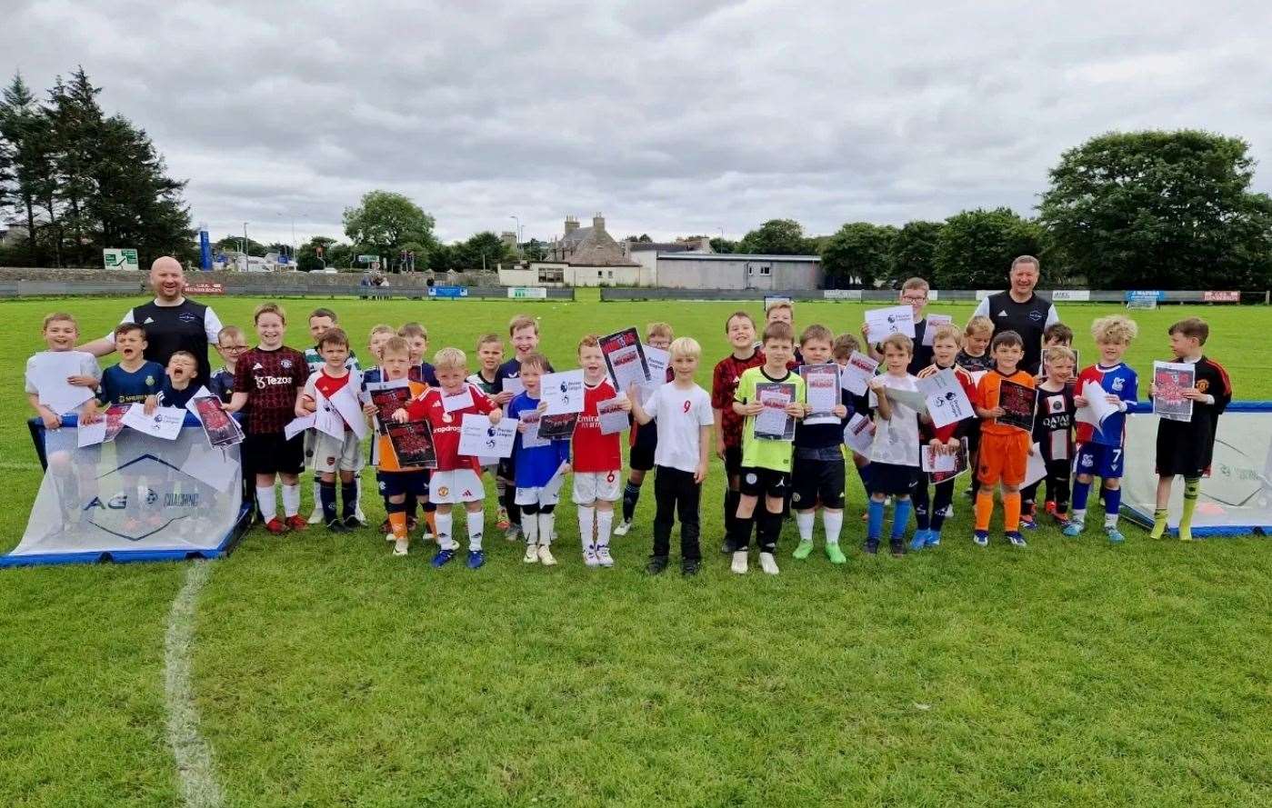 Keen young footballers from the five to nine section with the two Manchester United academy coaches.