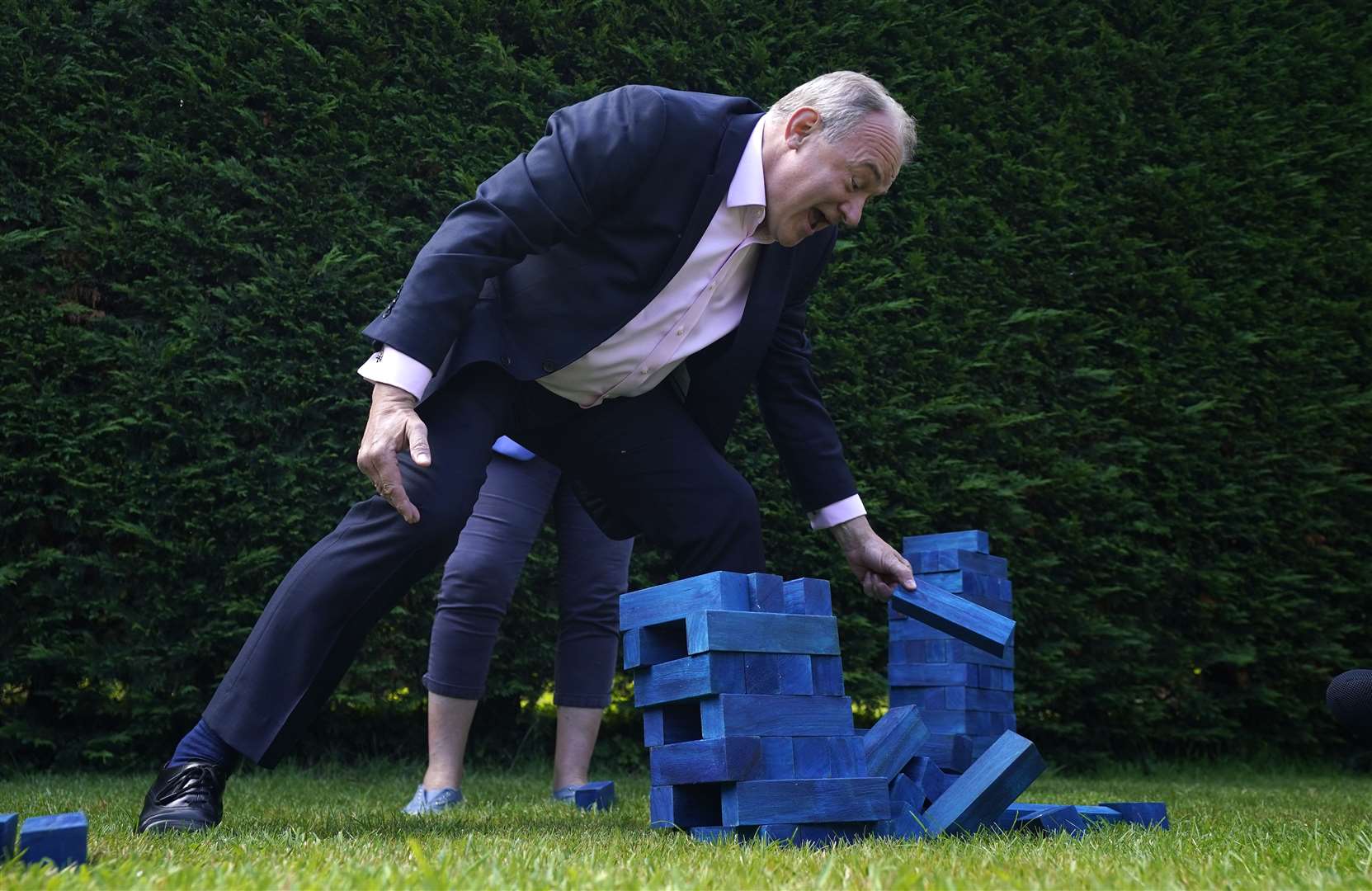 Liberal Democrats leader Sir Ed Davey plays Jenga with blue blocks representing the Conservative Party’s seats during a visit to Crowd Hill Farm, in Hampshire (Andrew Matthews/PA)