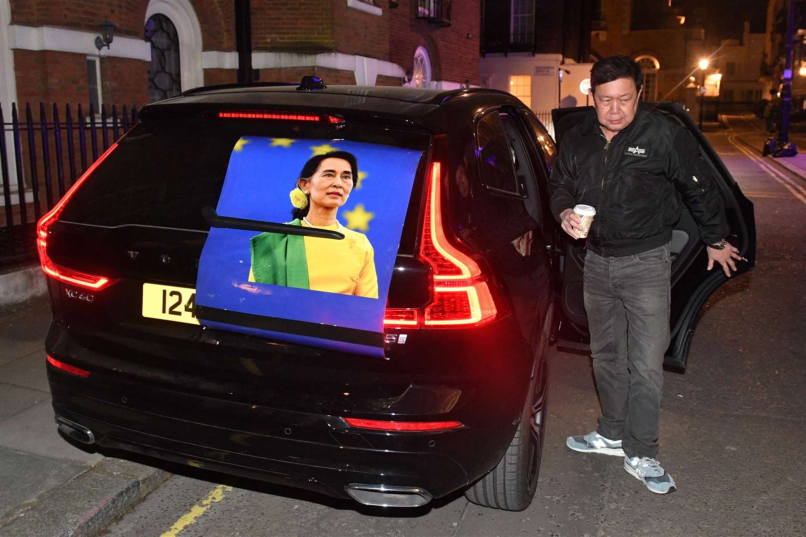 Kyaw Zwar Minn next to a car bearing the opposition leader’s image (Dominic Lipinski/PA)