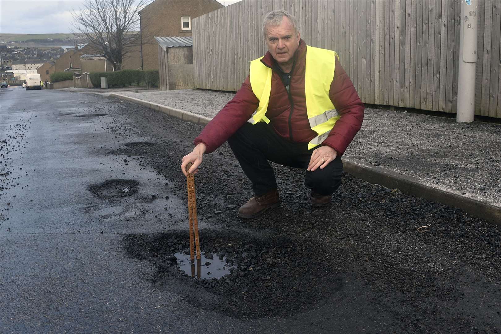 Councilor Ron Gunn measuring a pothole on Mount Pleasant Road oposite junction of Laurie Terrace - Thurso. Picture: Mel Brooks