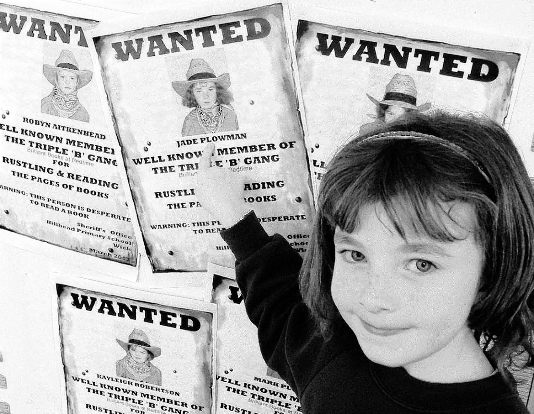 Hillhead P3 pupil Jade Plowman in 2007 pointing to her own ‘Wanted’ poster as a member of the Triple ‘B’ gang (Brilliant Books at Bedtime), a reading initiative that ran for 16 weeks.