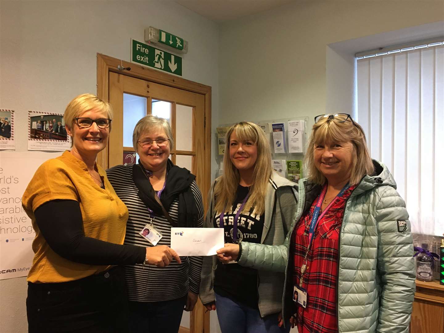 Hearing and Sight Care manager Deirdre Aitken (left) receives a cheque from BT staff representatives (from second left) Susan McDonald, Karon Jappy and Hannah Perriewood.