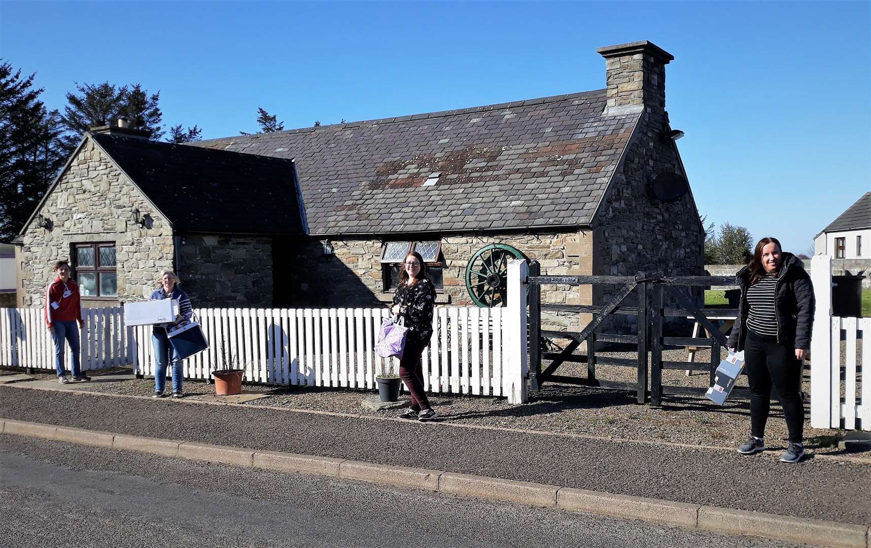Local volunteers observe social distancing as they queue outside the Old Smiddy Inn for meals they deliver around homes in the Thrumster area. Picture: Raymond Bremner