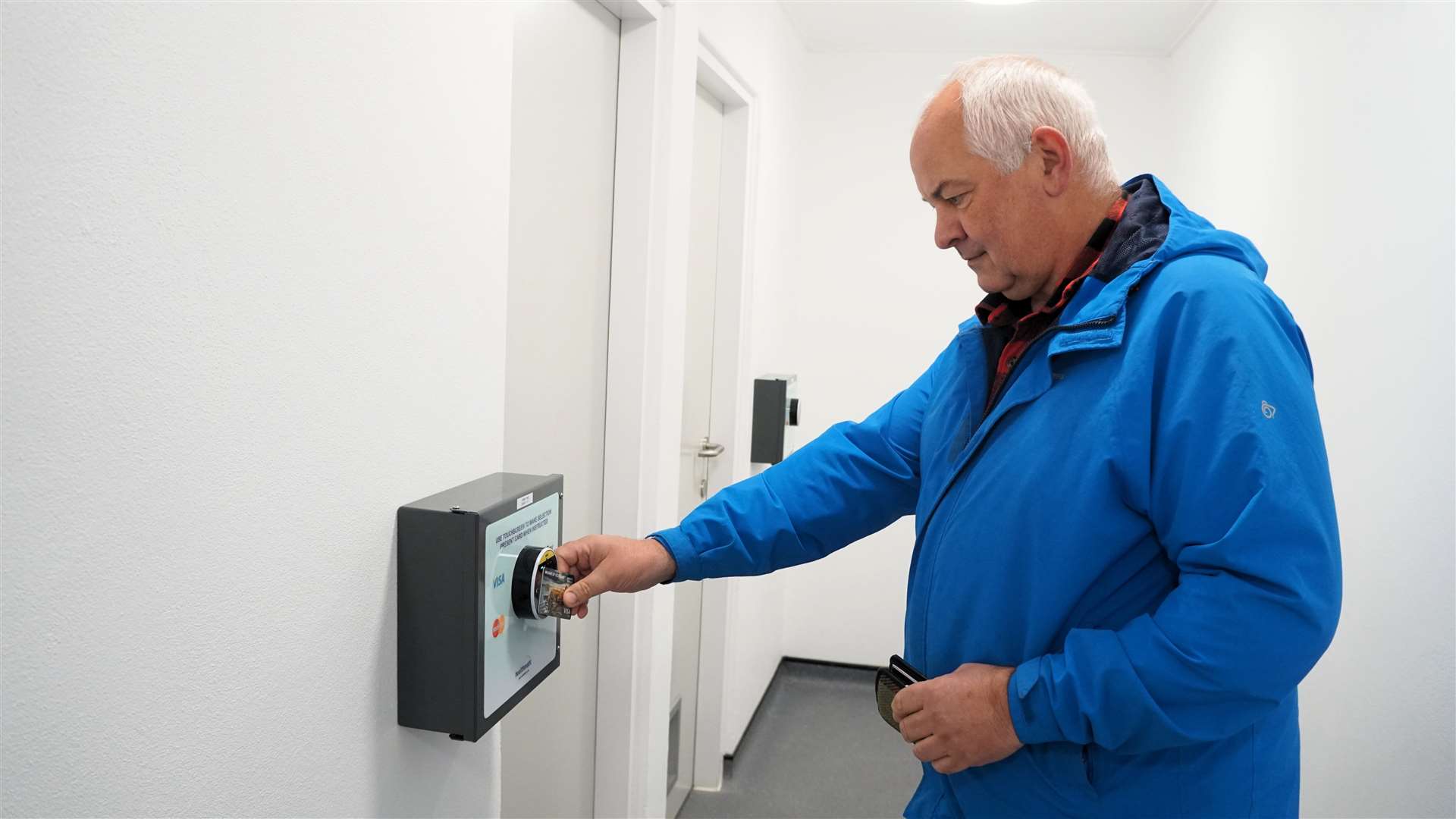 Cllr Raymond Bremner tries the touchscreen for the shower cubicles. Picture: DGS