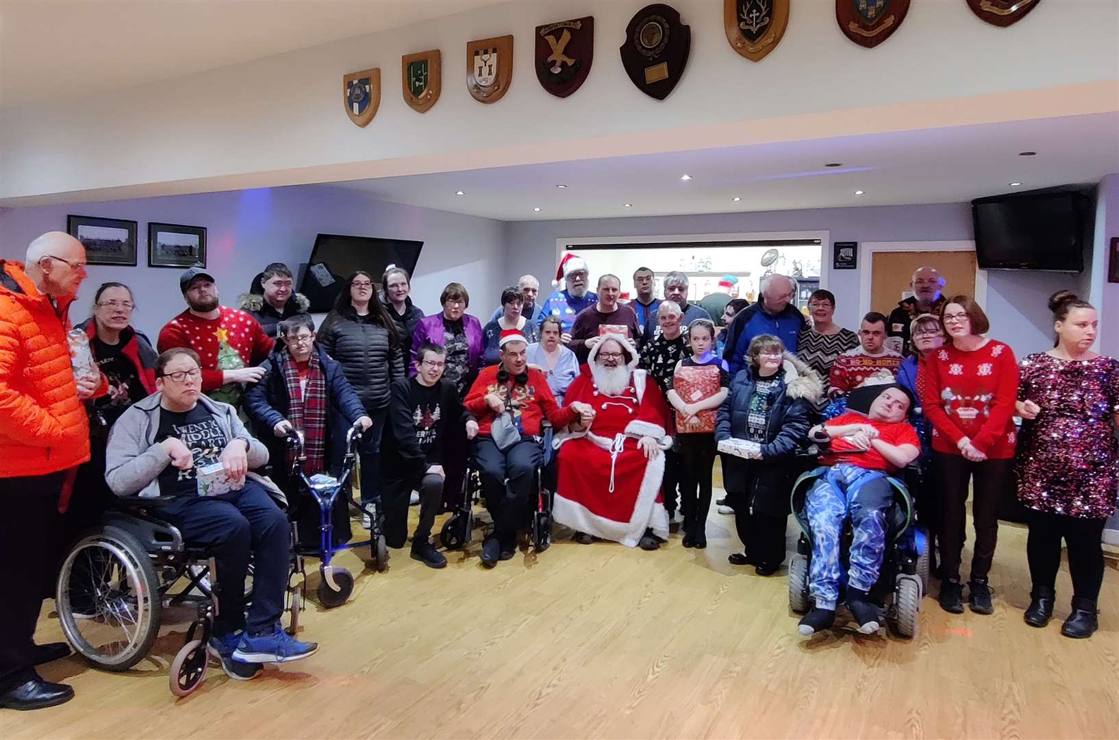 Monday Club members gather around Santa at their Christmas party in the Caithness rugby club pavilion. Picture: Fiona Harrington
