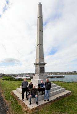 The refurbished James Bremner monument in Wick with Callum Miller (centre), his son Mikie (right) and (from left) Wick Paths Group chairman Allan Tait, secretary John Bogle and member Charlie Bain with his dog Jet. Picture: Robert MacDonald / Northern Stu