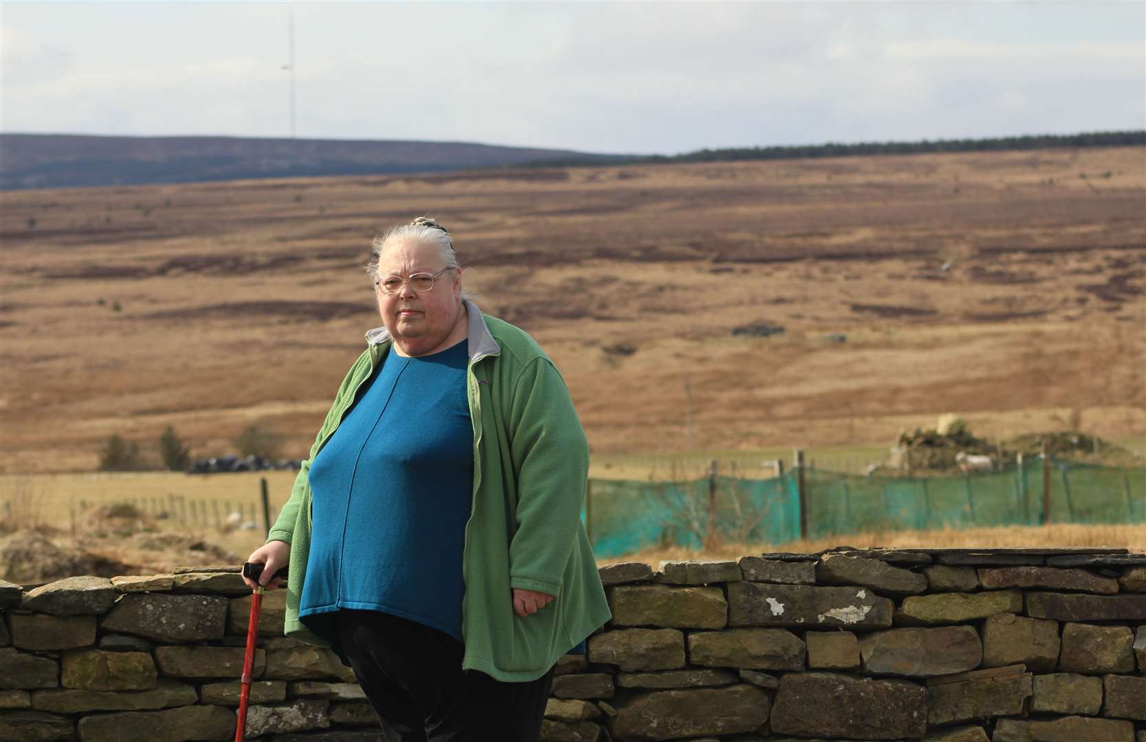 Jo Bowd outside her cottage at Roster, north of Lybster, with the Golticlay site in the distance. Picture: Alan Hendry