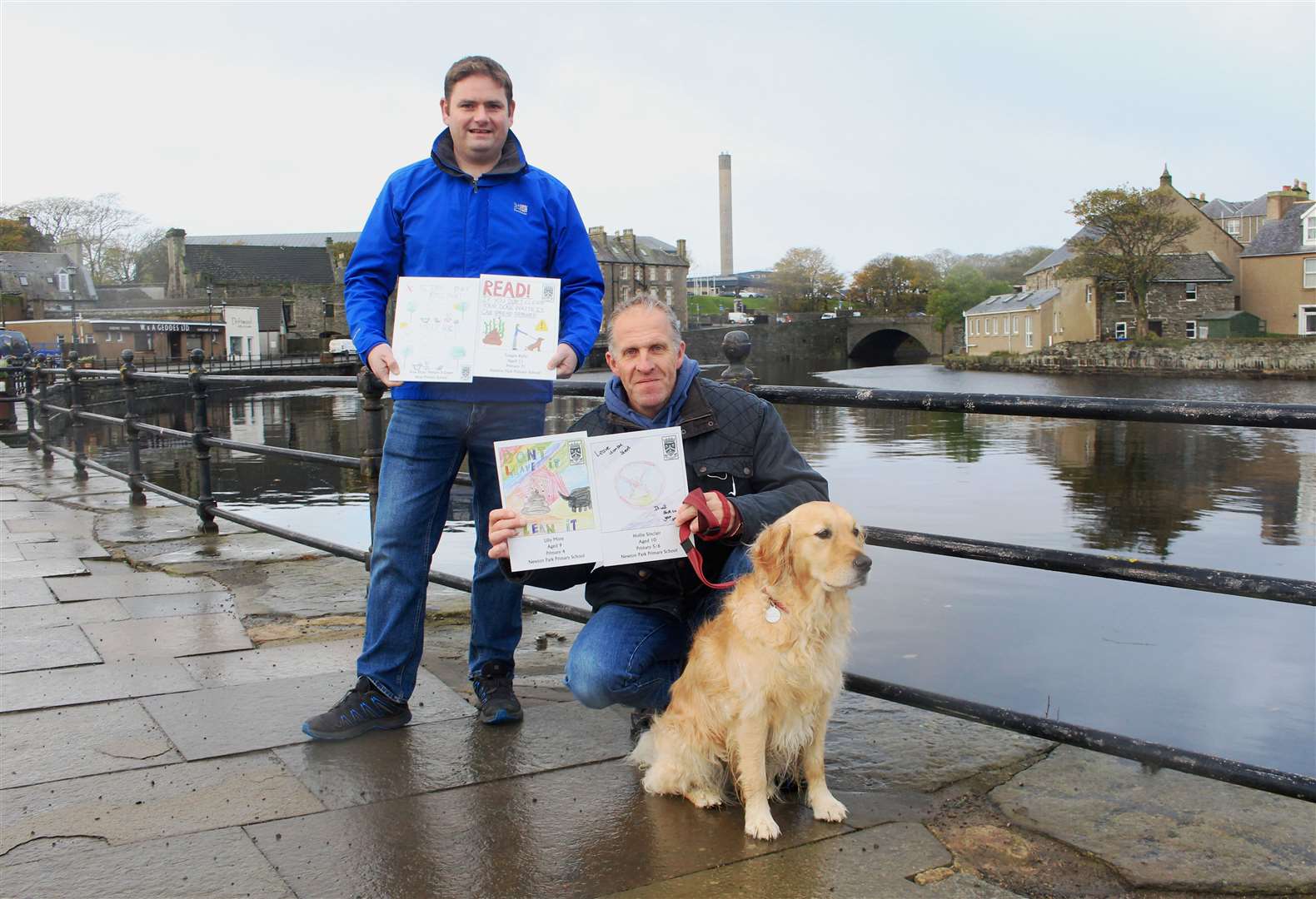 Community councillors Allan Bruce (left) and Alastair Ferrier holding the winning poster designs, accompanied by Mr Ferrier's dog Lucy. Picture: Alan Hendry