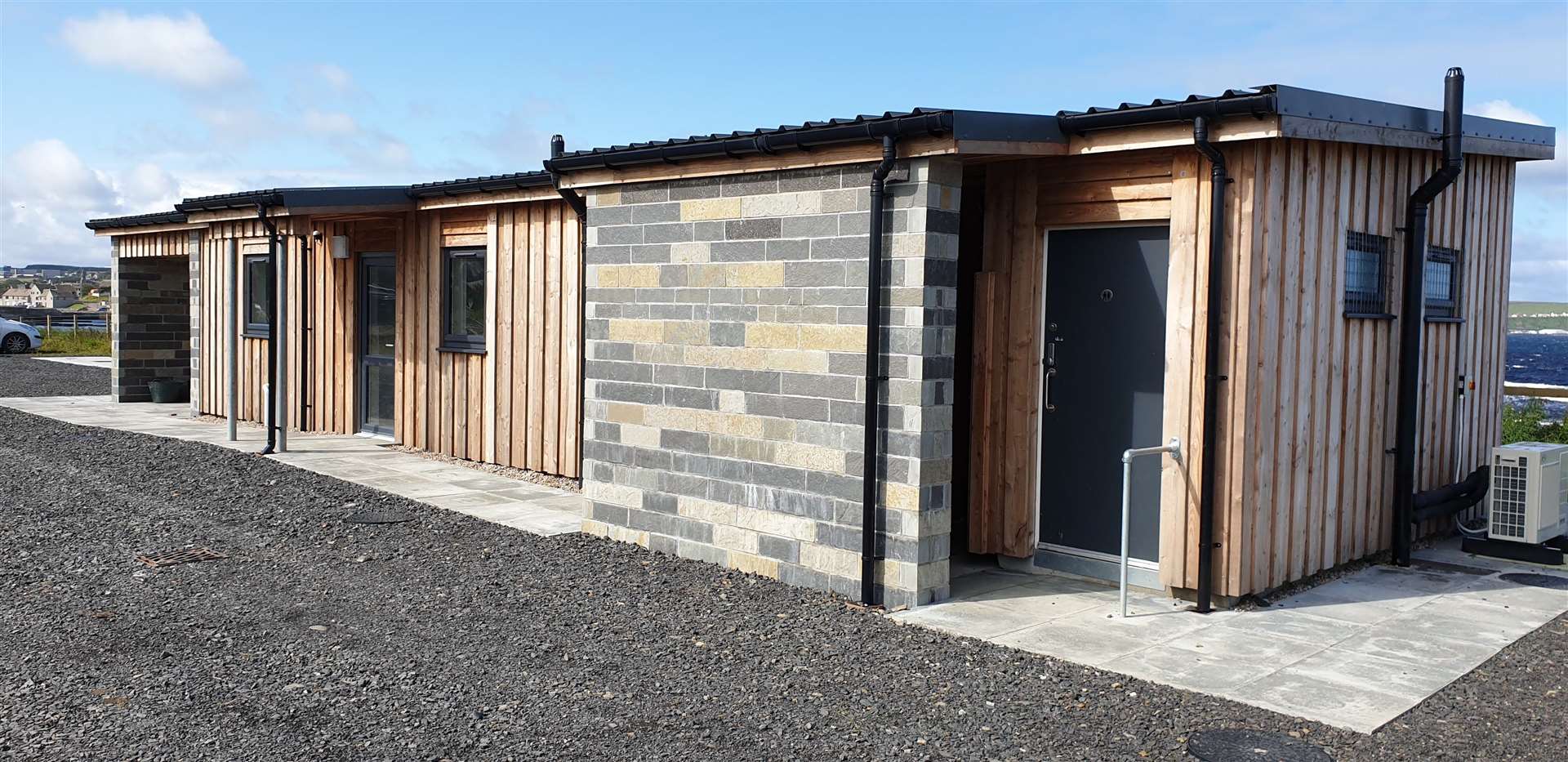 The timber-clad building has toilets, showers, a meeting room, a safety equipment store, a covered viewing area and a waste store.
