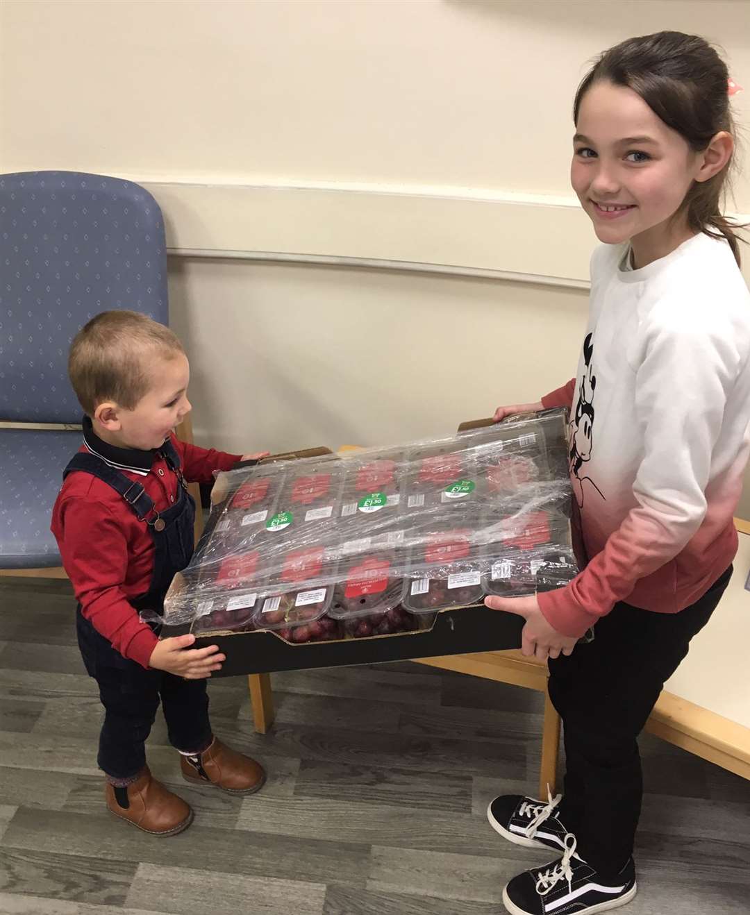 Zander gives big sister Aurora a helping hand with the grapes they they gifted to Caithness General Hospital.