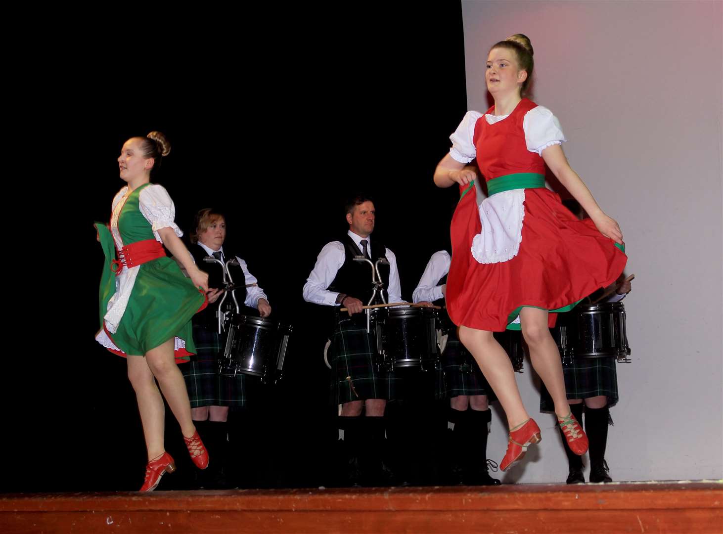 Susie Lyall and Megan Sutherland with pipe band members in the background. Picture: Alan Hendry