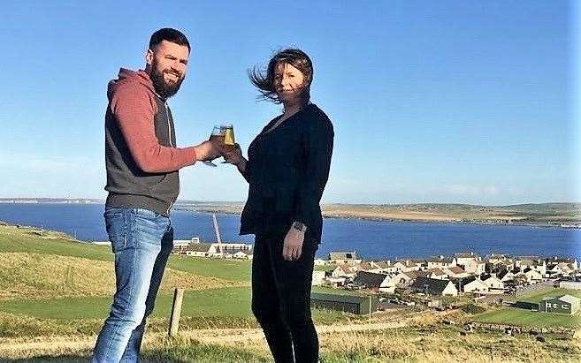 Alan and Lesley have a beer on the brae overlooking the area where their microbrewery will be built.