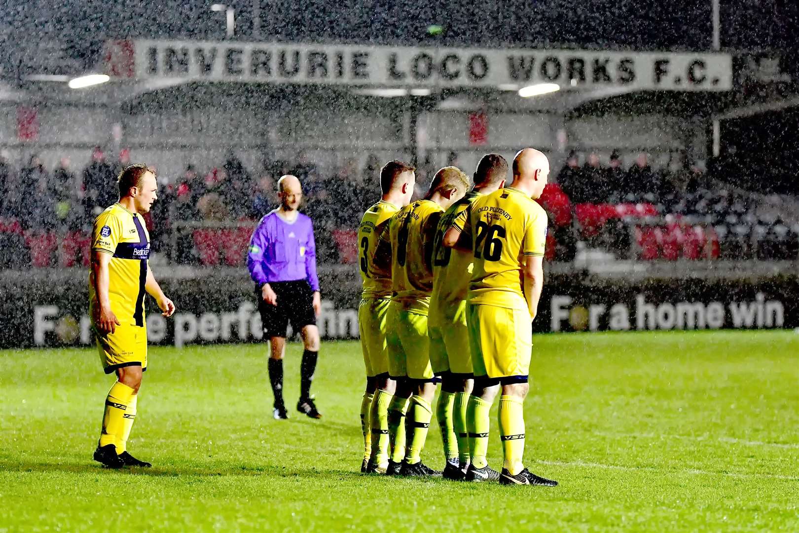 Wick Academy players defend a free kick as conditions worsen at Harlaw Park on Wednesday night. Picture: Mel Roger