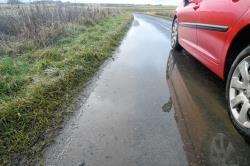 A motorist swerves to avoid a pool on the side road between Watten and Mybster which is particularly prone to build-ups of surface water.
