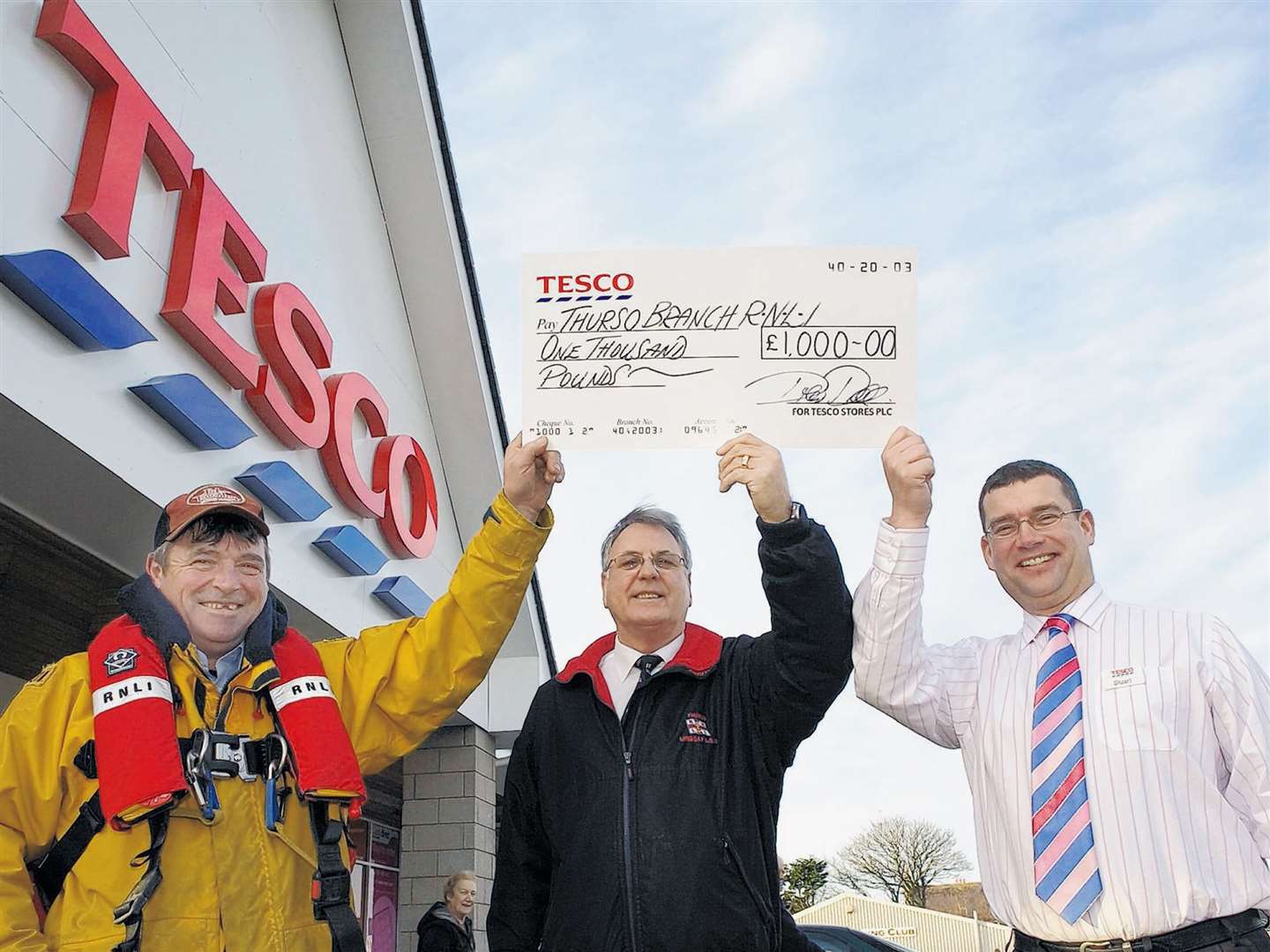 Tesco’s Thurso store manager Stuart Cowan (right) presenting a £1000 cheque to Brian Williams, Thurso lifeboat operations manager, while looking on is coxswain William “Wing” Munro, in 2008.