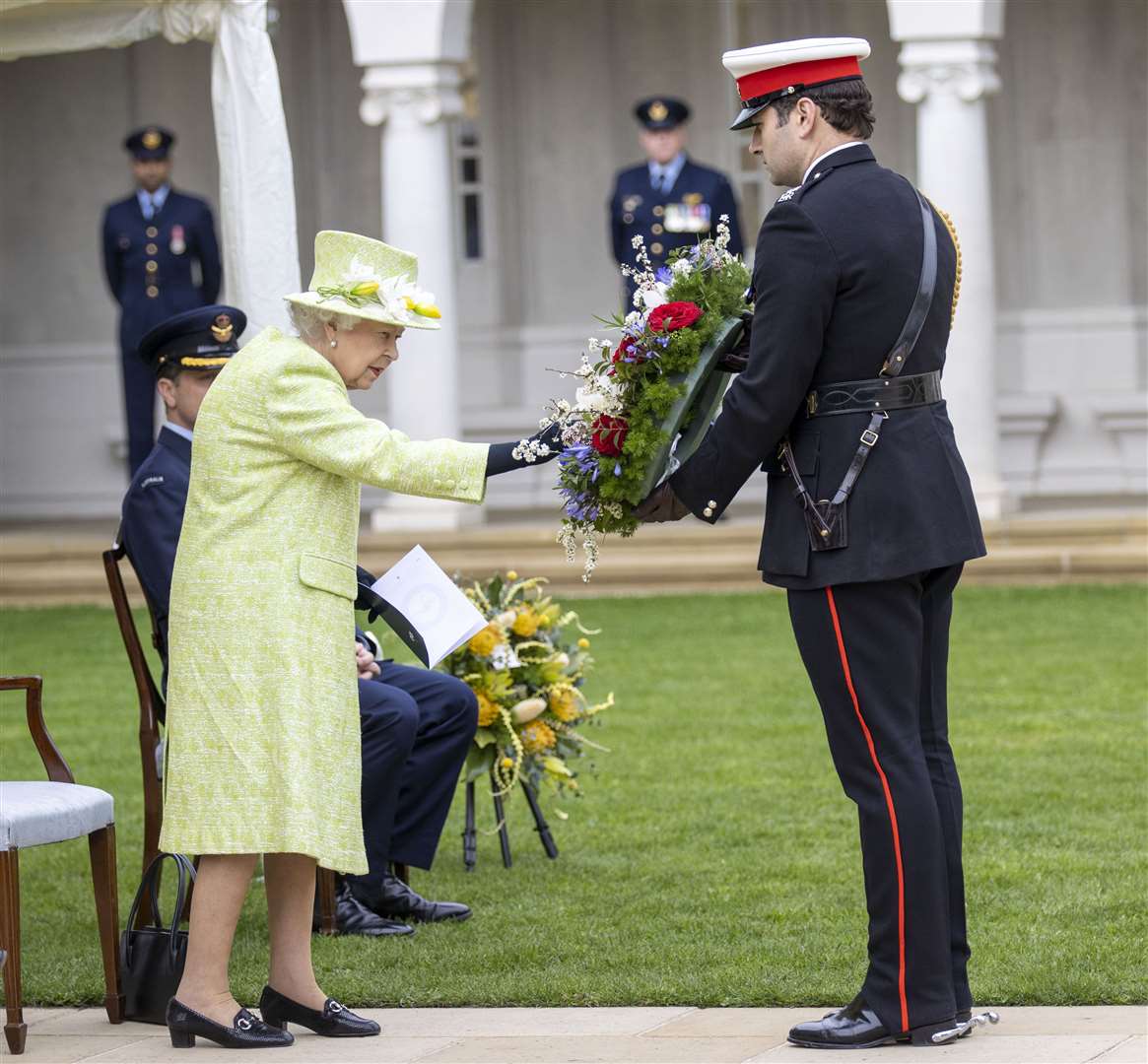 The Queen touches her wreath before it is laid on her behalf (Steve Reigate/Daily Express/PA)