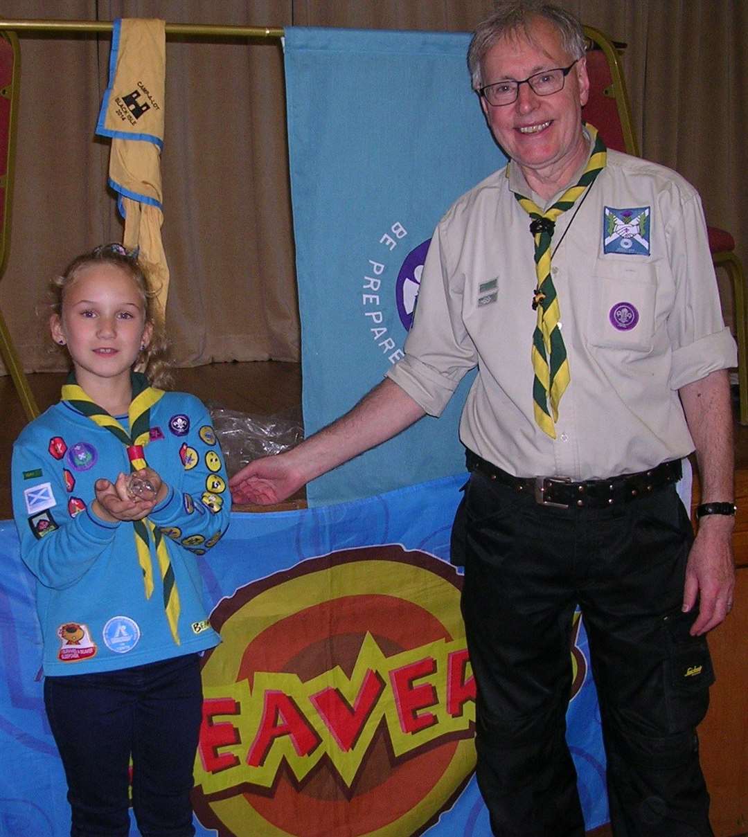 Emma Sutherland is presented with her badge by Reay Beaver Scout leader Ian Pearson.
