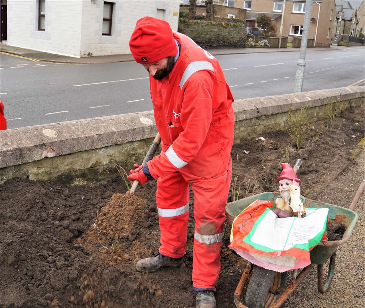 Alexander shovels in new topsoil to ensure the new roses will have a healthy start. Picture: DGS