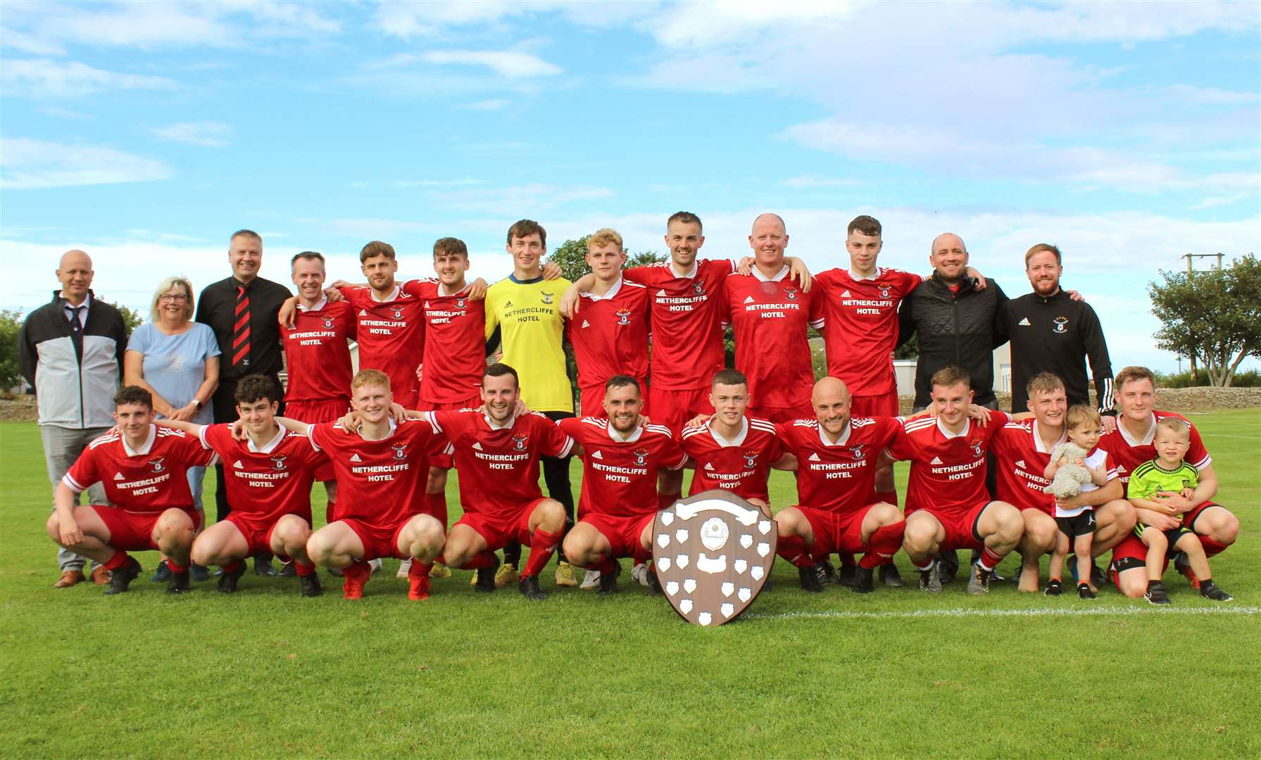 Wick Groats players and management after their victory over High Ormlie Hotspur in Saturday's David Allan Shield final at Castletown, with Linda Moran, daughter of David Allan, and Andrew Lannon, Caithness AFA secretary (left). Picture: Picture House Films