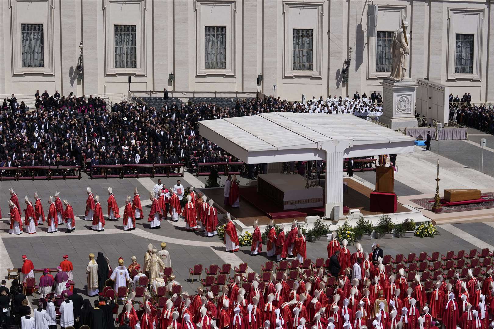 Cardinals leave at the end of the funeral of Pope Francis as his coffin is seen at the right, in St Peter’s Square at the Vatican (Gregorio Borgia/AP)