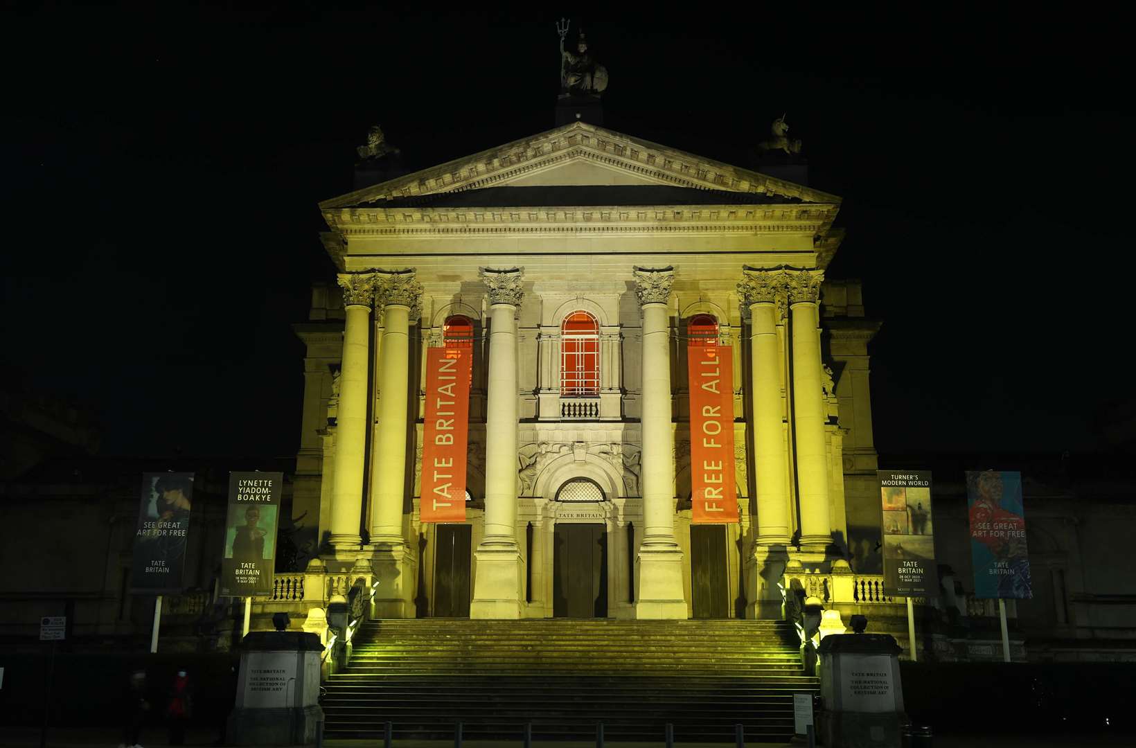 The Tate Britain in London is illuminated yellow during the National Day of Reflection, on the anniversary of the first national lockdown (Yui Mok/PA)