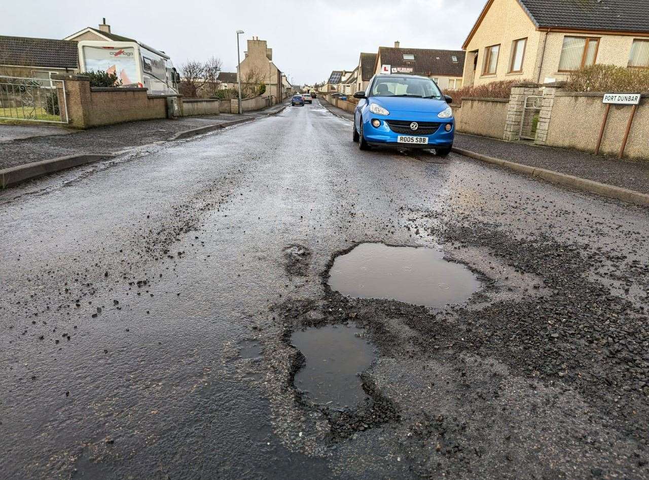 Ross Bain's car in front of a potholed section of Port Dunbar.