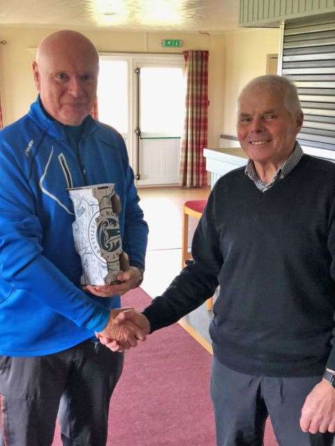 Stuart Greig (left) receiving a bottle of North Point gin from senior section convener Sandy Chisholm after winning the nearest-the-pin prize during round two of the North Point Distillery Senior Stableford competition.